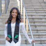 Skylar Allen wearing a UNT stole on outdoor campus stairs in Denton