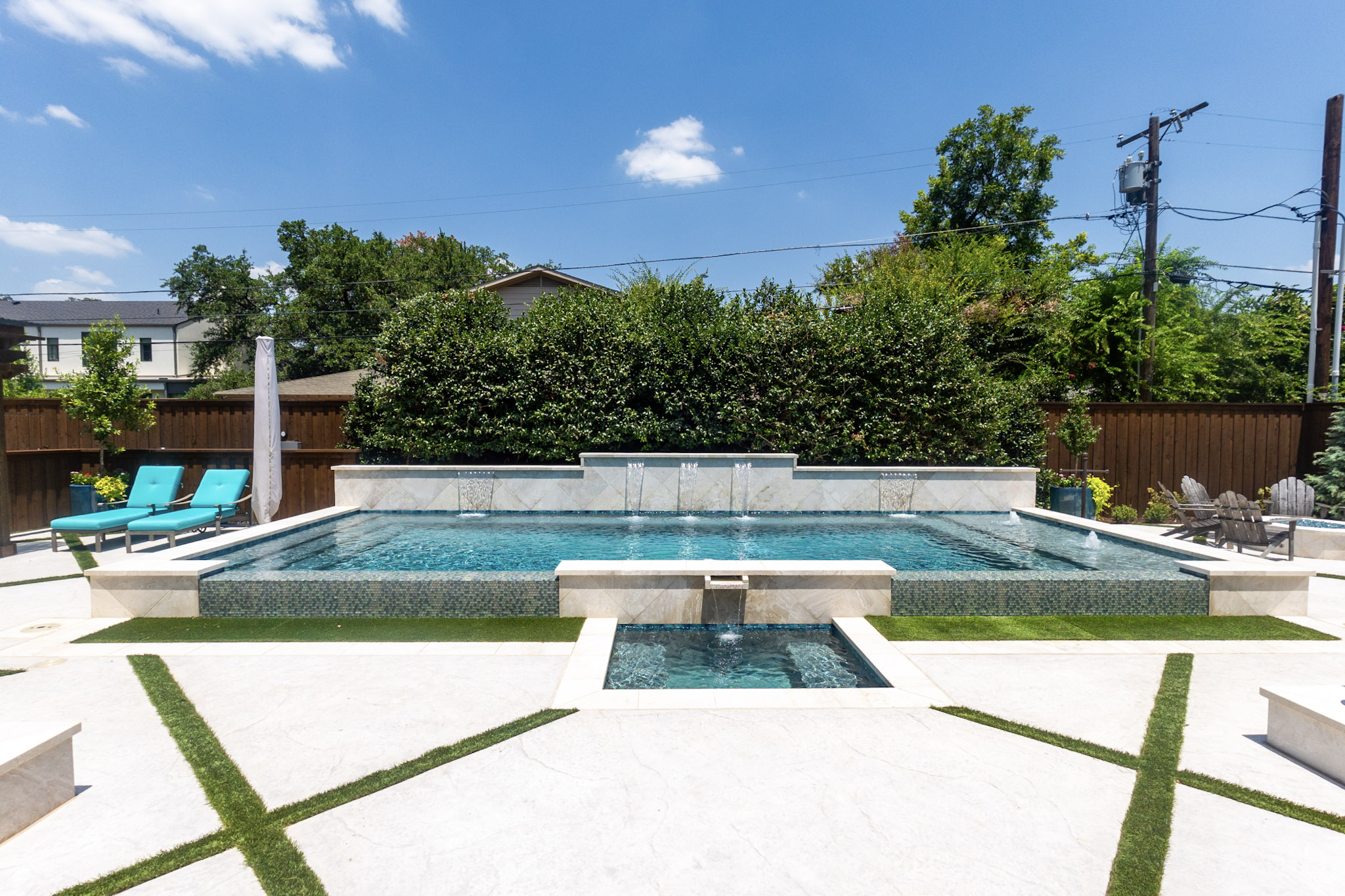 Front view of luxury vanishing edge pool with spa and water features in University Park, TX