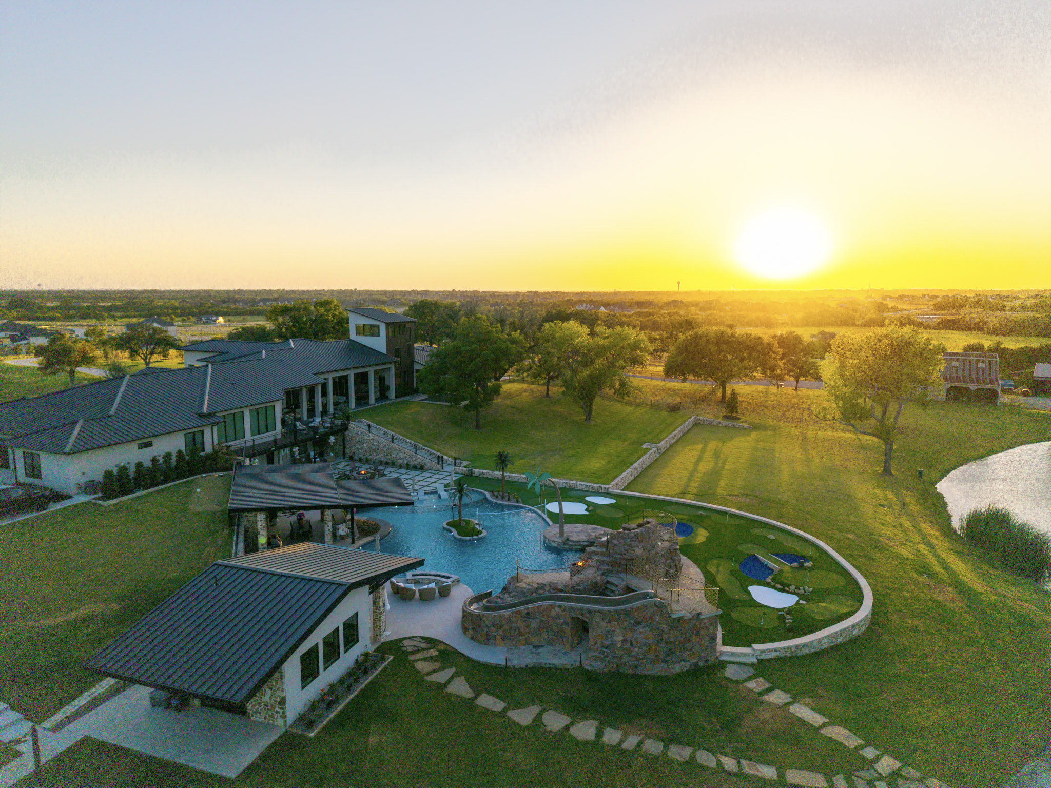 Sunset aerial of large resort-style pool and surrounding Rockwall property.