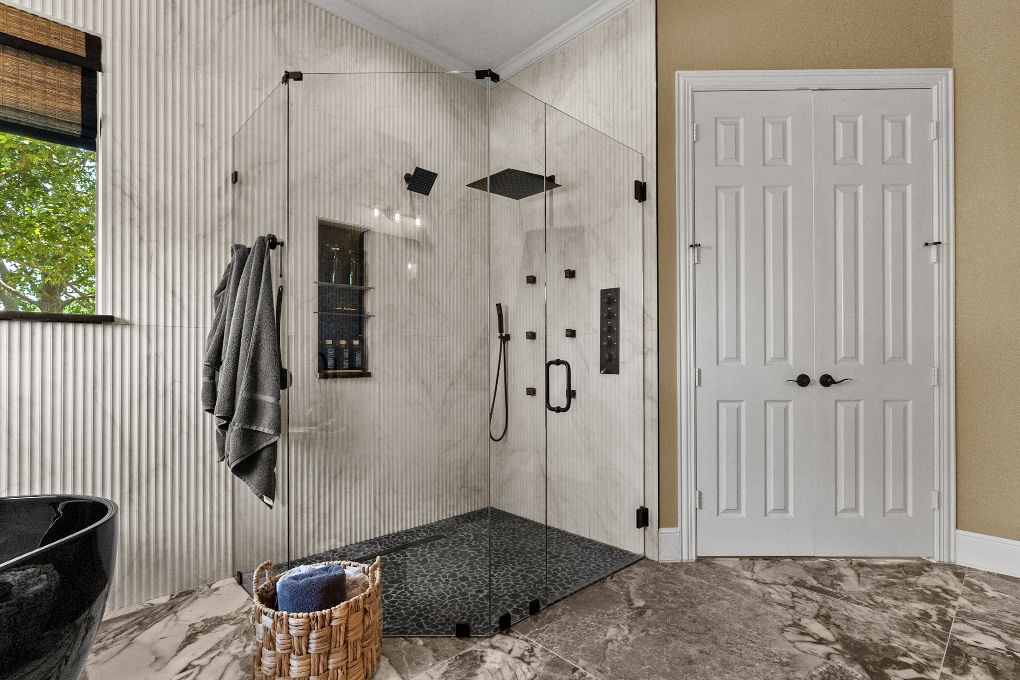 Frameless glass shower with black fixtures in Celina, Texas bathroom remodel