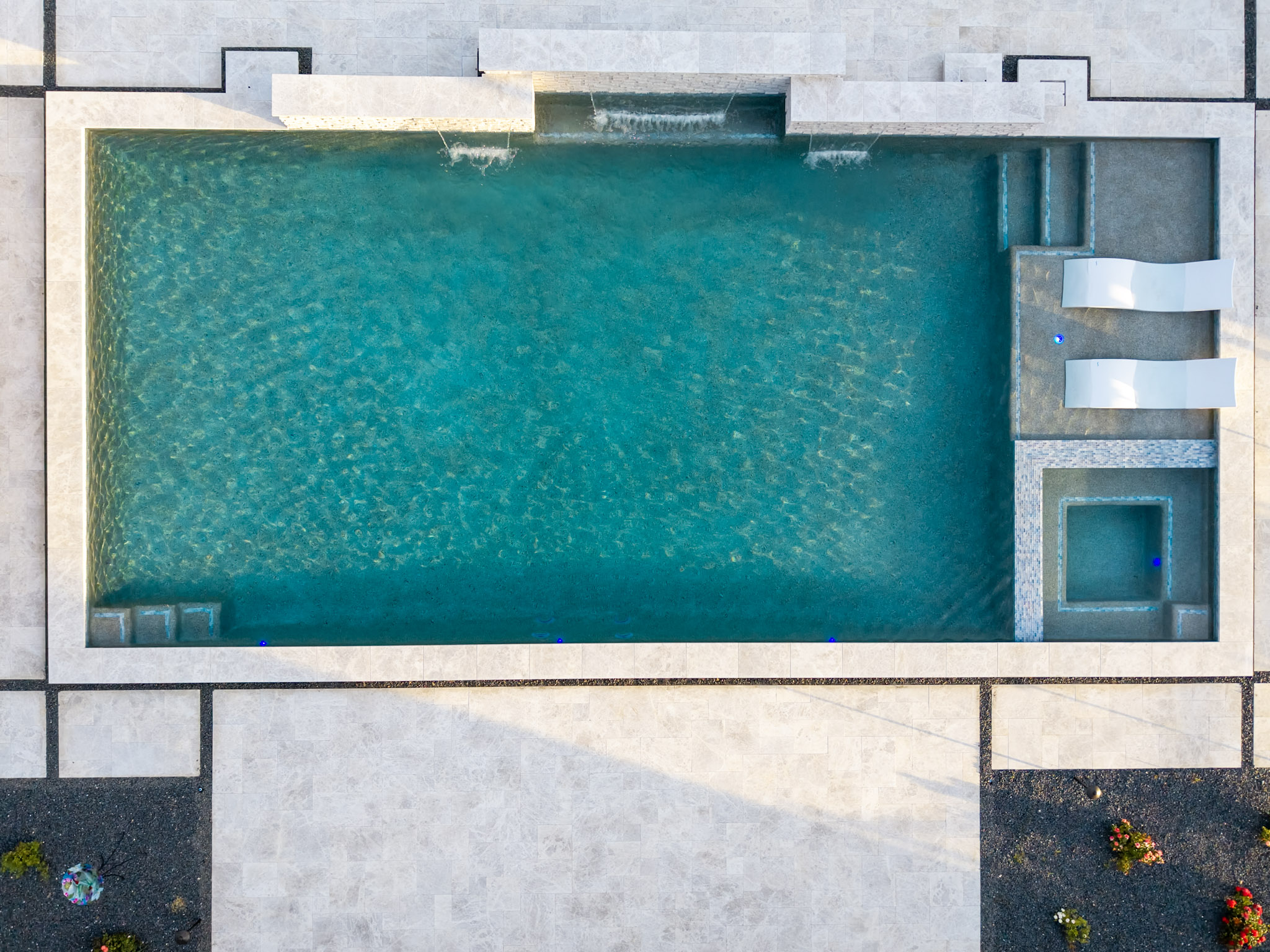 Overhead drone photograph of Azle pool with spa, loungers and sheer descents.