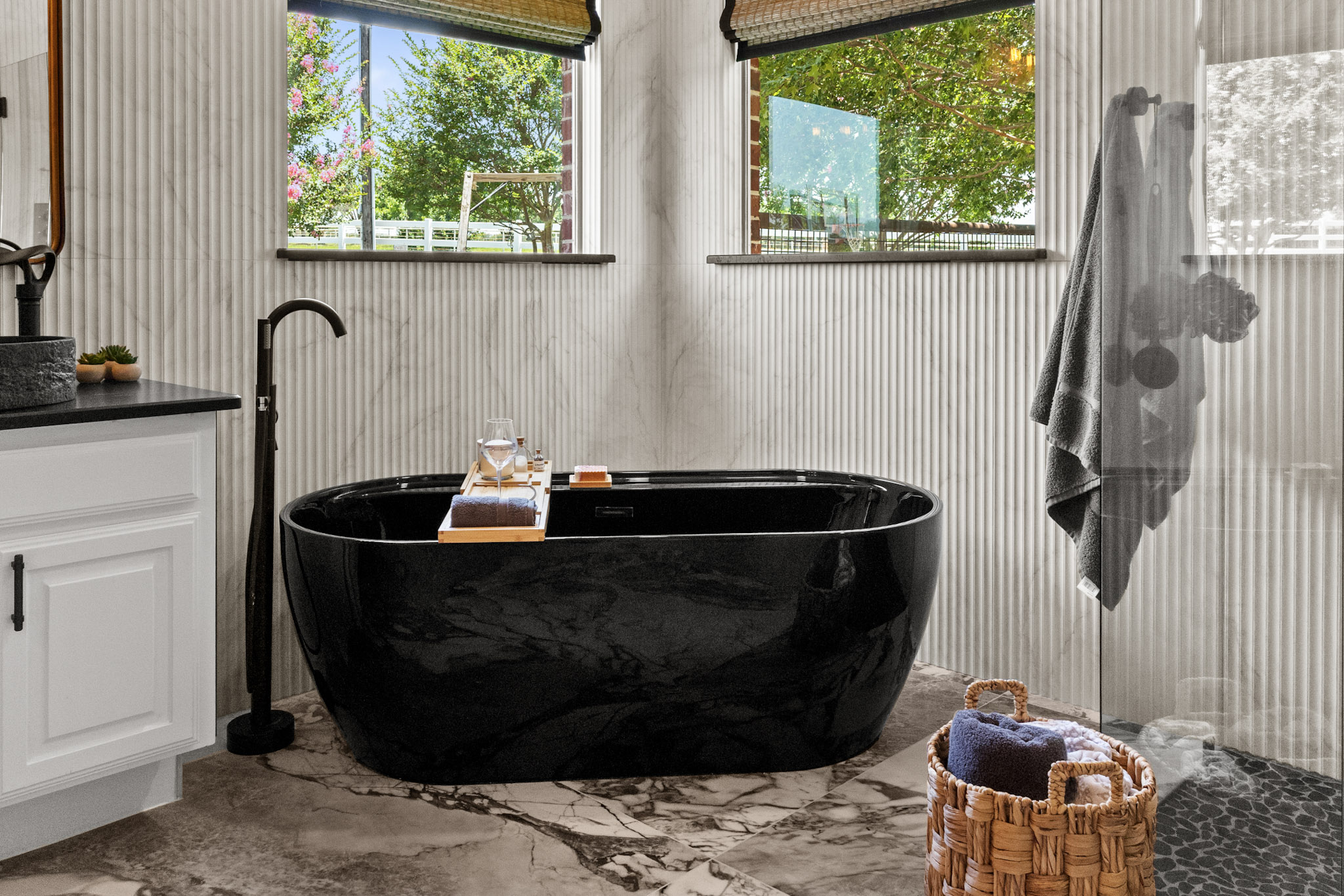 Black freestanding bathtub in remodeled primary bathroom in Celina, Texas