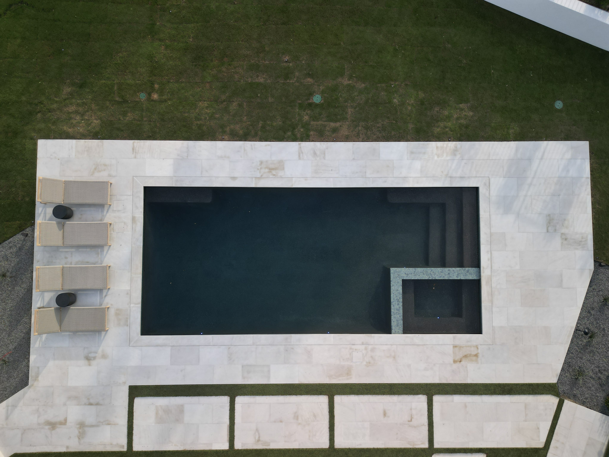 Overhead drone view of rectangular pool with integrated spa and limestone deck.