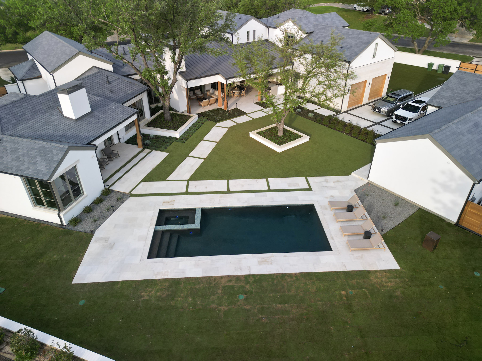 Aerial view of rectangular pool, lawn, limestone walkways and Fort Worth residence.