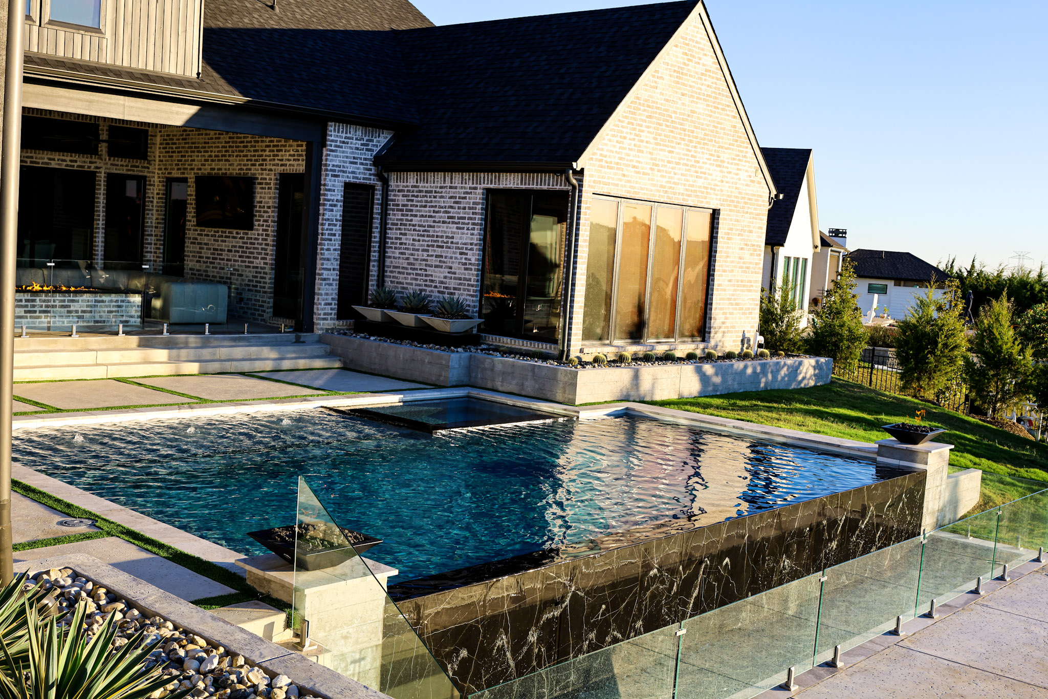 Linear fire table beside luxury pool during golden hour in Heath.