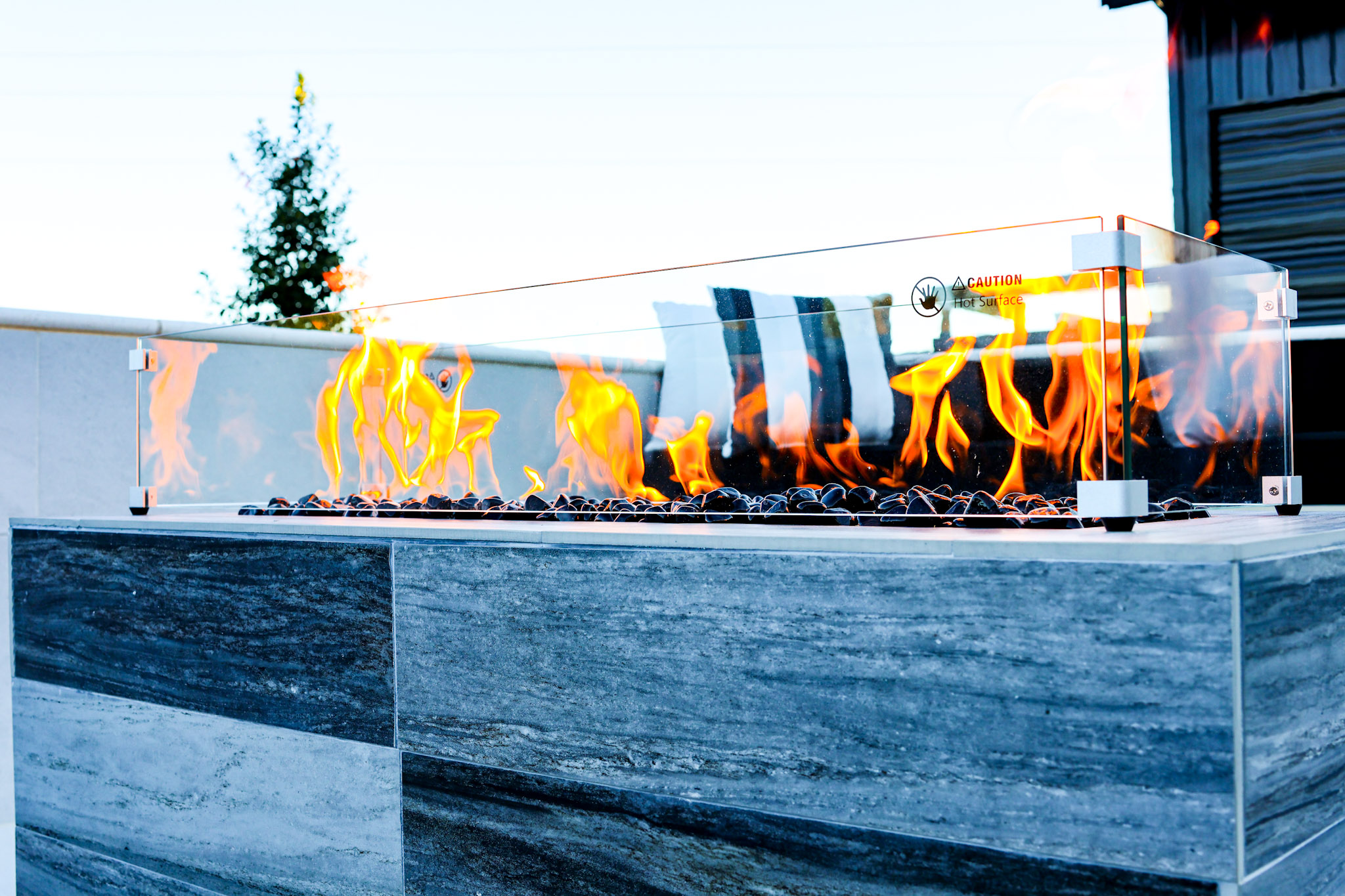 Close architectural detail of the gas fire feature within the project's sunken poolside lounge.