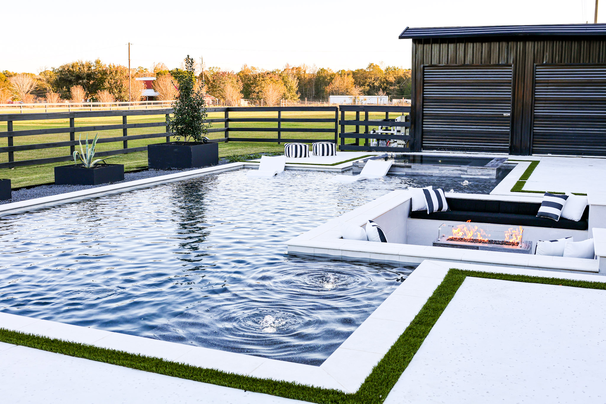 Geometric swimming pool with integrated sunken fire lounge, raised spa and tanning area.