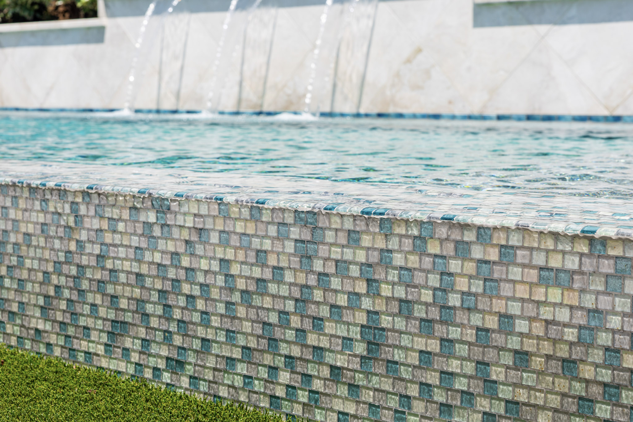 Glass mosaic tile detail on vanishing edge swimming pool