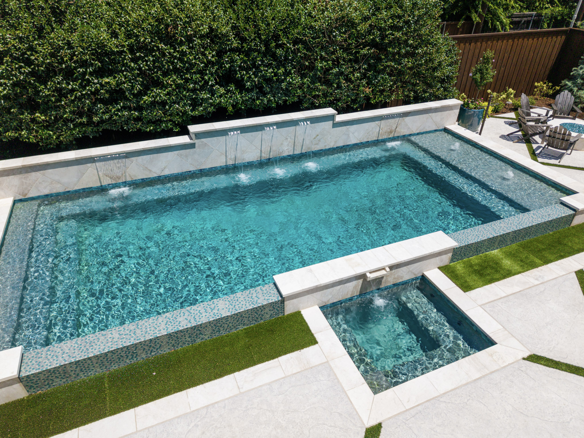 Elevated view of vanishing edge pool and spa with water features in University Park, TX