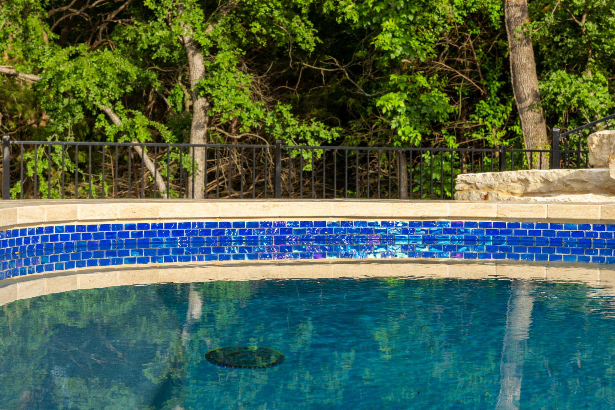 Blue glass swimming pool tile detail at luxury Weston, Texas outdoor living project