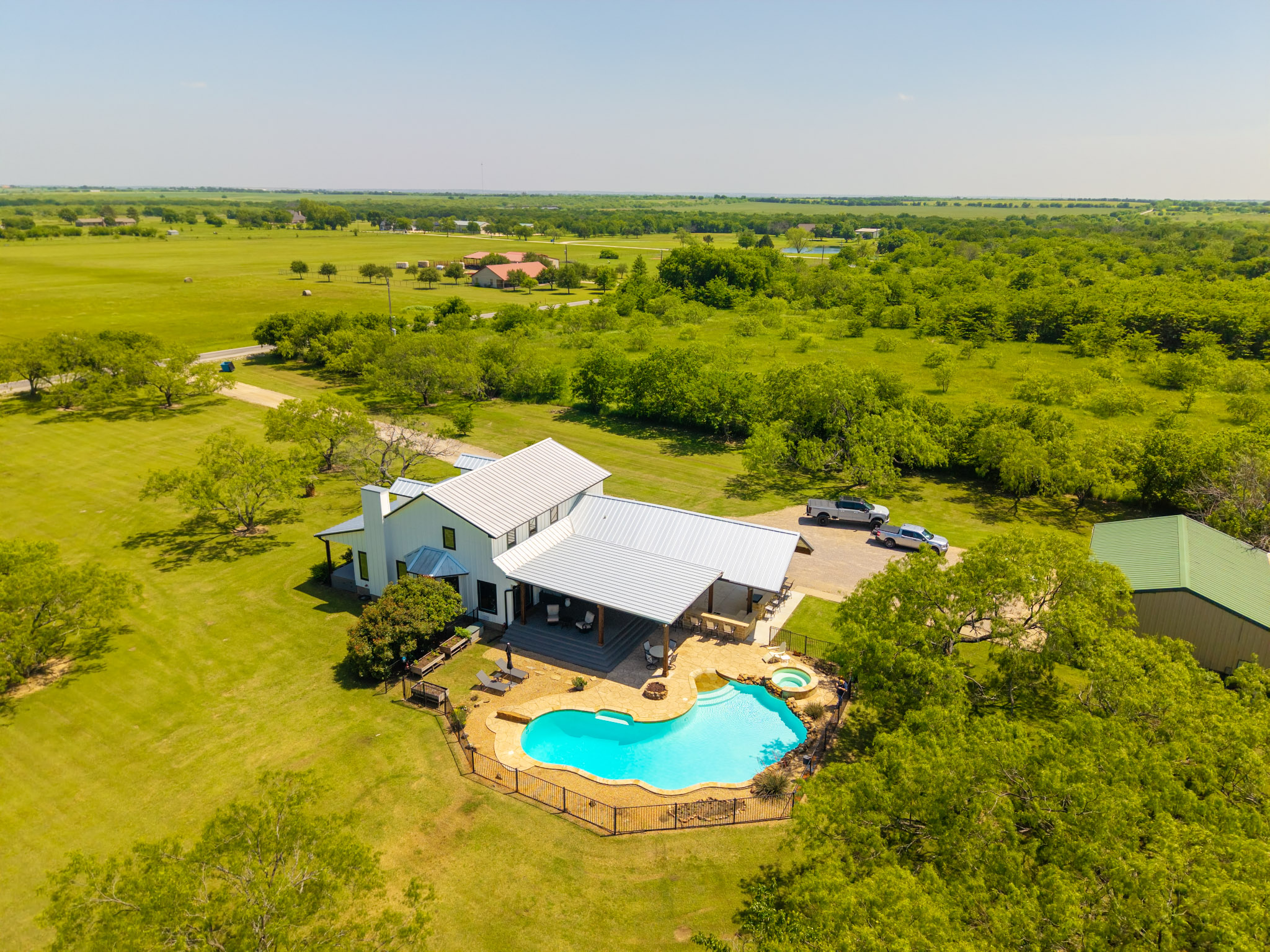 Elevated view of a Tioga home with covered patios, pool, spa and surrounding acreage.