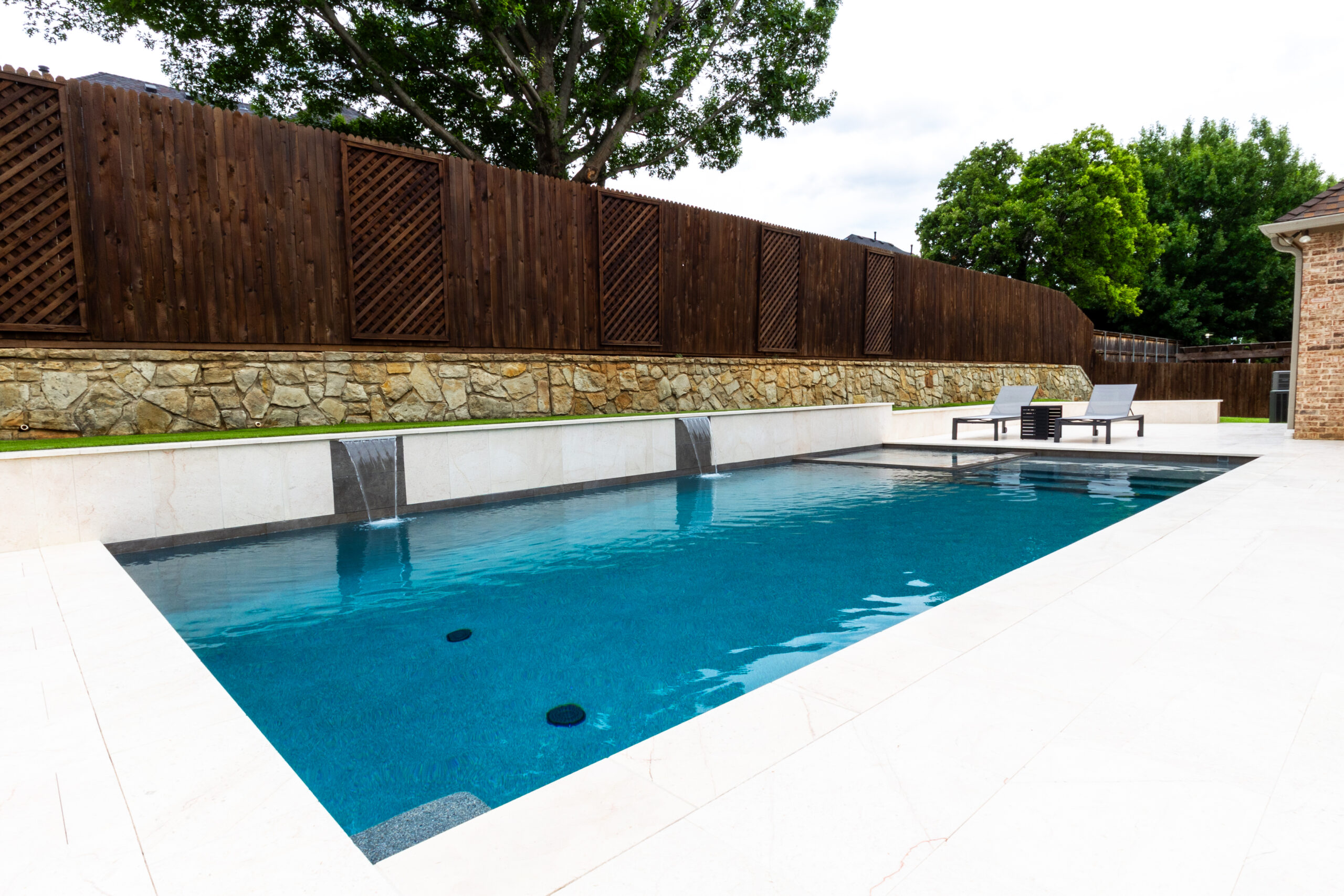 Custom swimming pool and spa with two sheer descent waterfalls by RiverMist Pools & Spas in Colleyville.