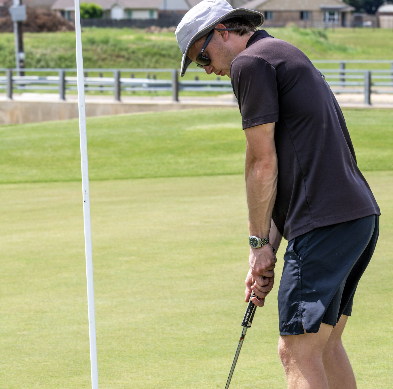 Golfer lining up a putt beside the flag on a putting green