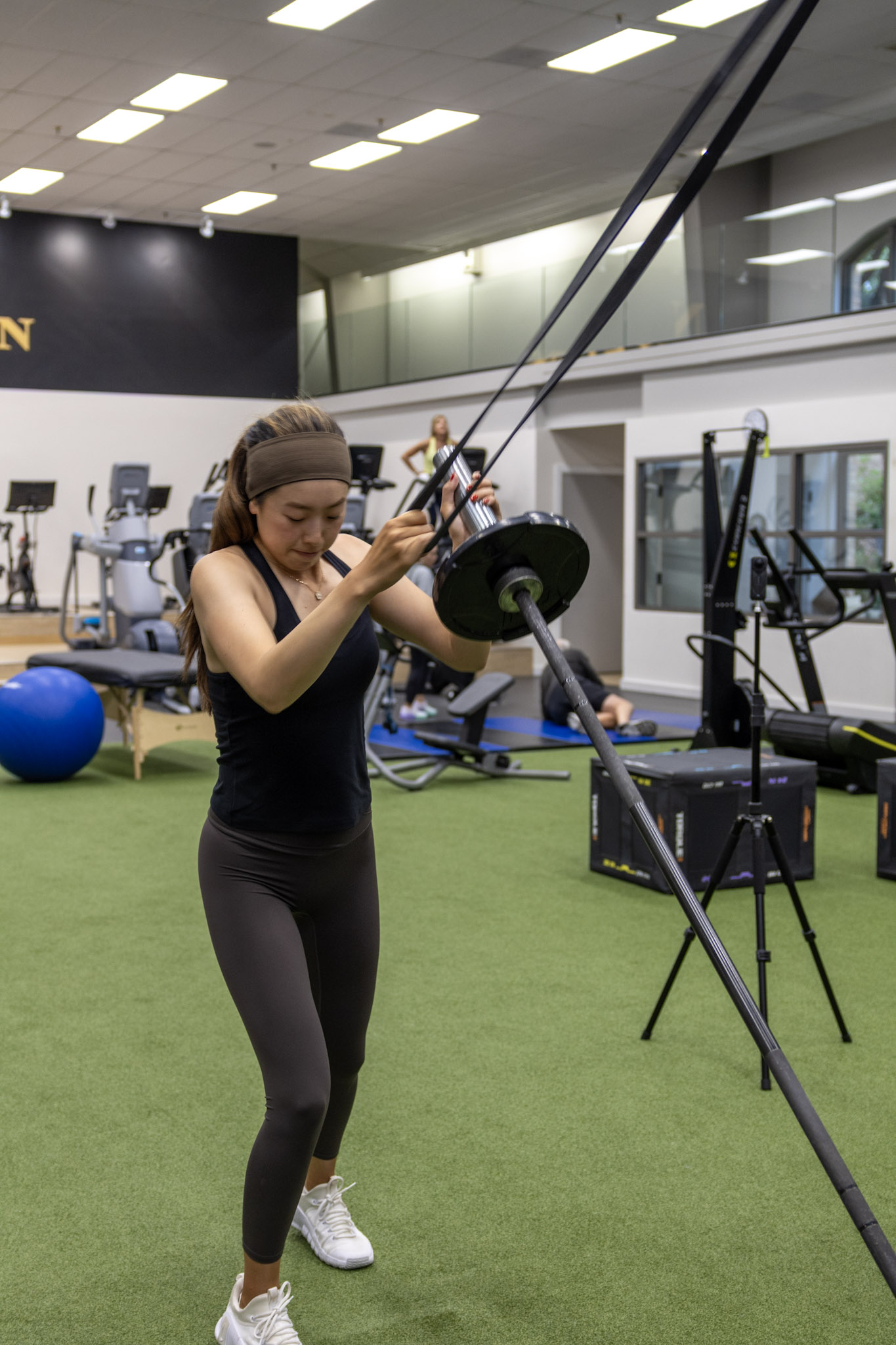 Athlete performing a resistance exercise with weighted equipment inside The Nelson Sports facility.