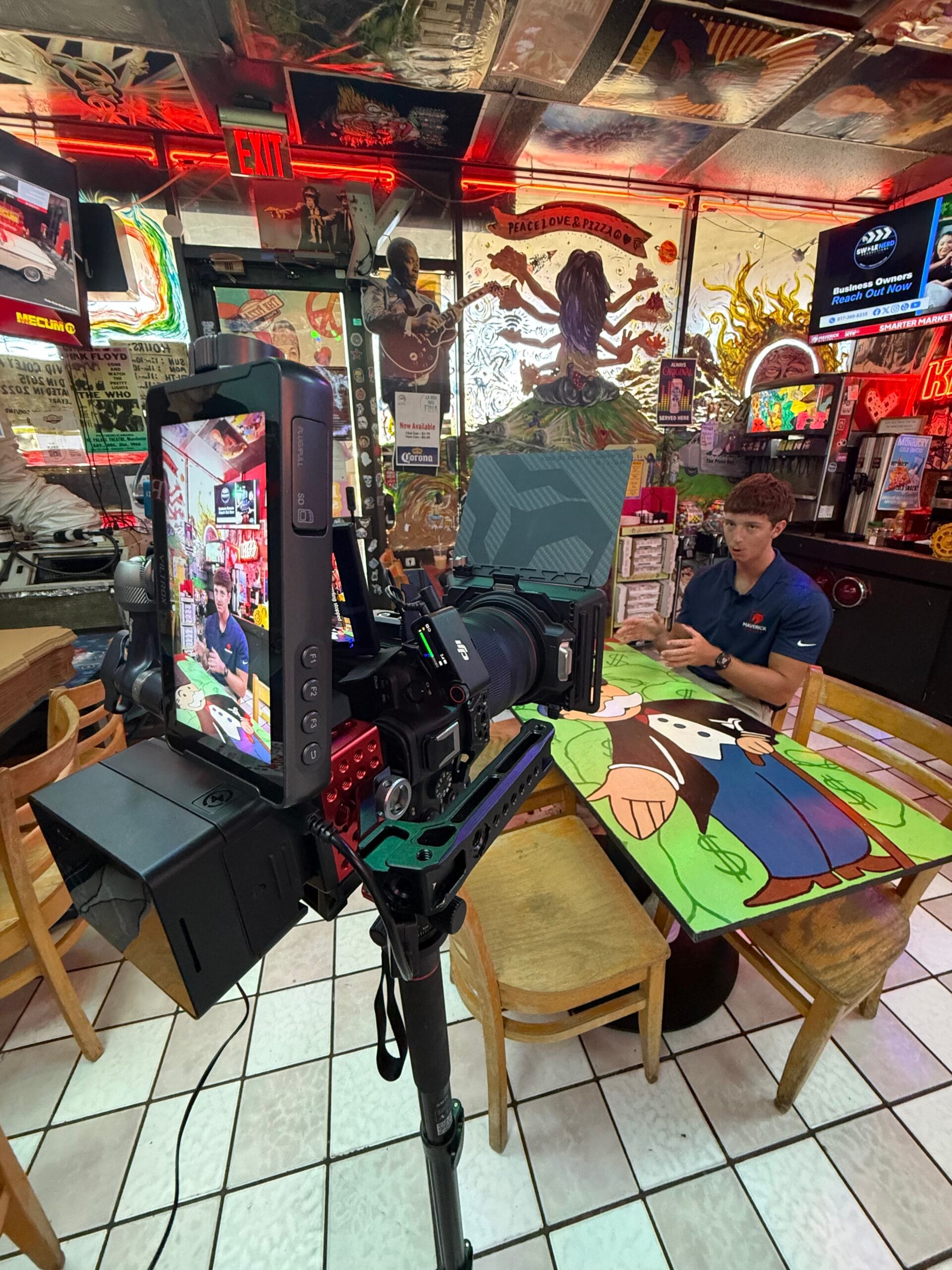 Behind-the-scenes view of a professional camera recording a business owner for branded video content.