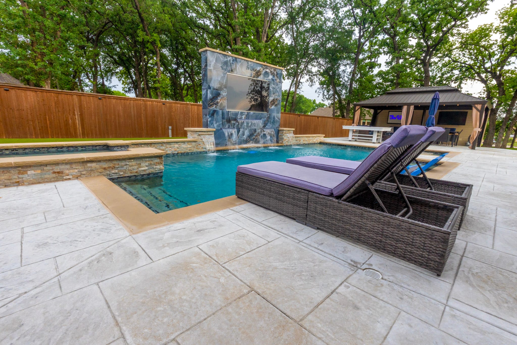Large-format porcelain water feature with multiple sheer descents into pool