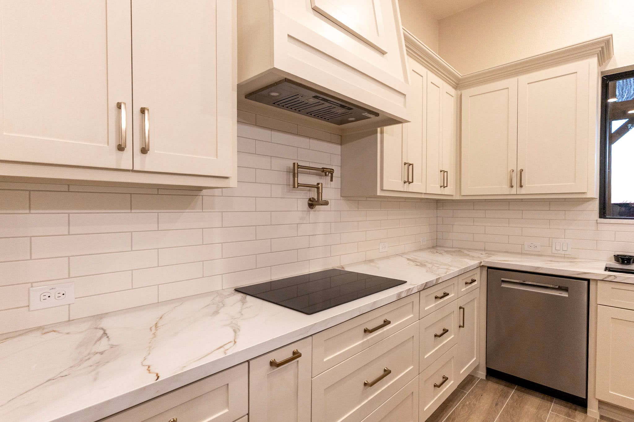 White barndominium kitchen cabinets with veined countertop and cooktop