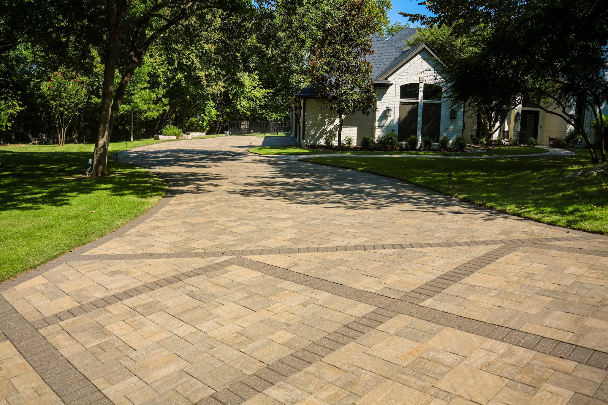 Wide view of Belgard paver driveway at a Fairview home surrounded by mature trees