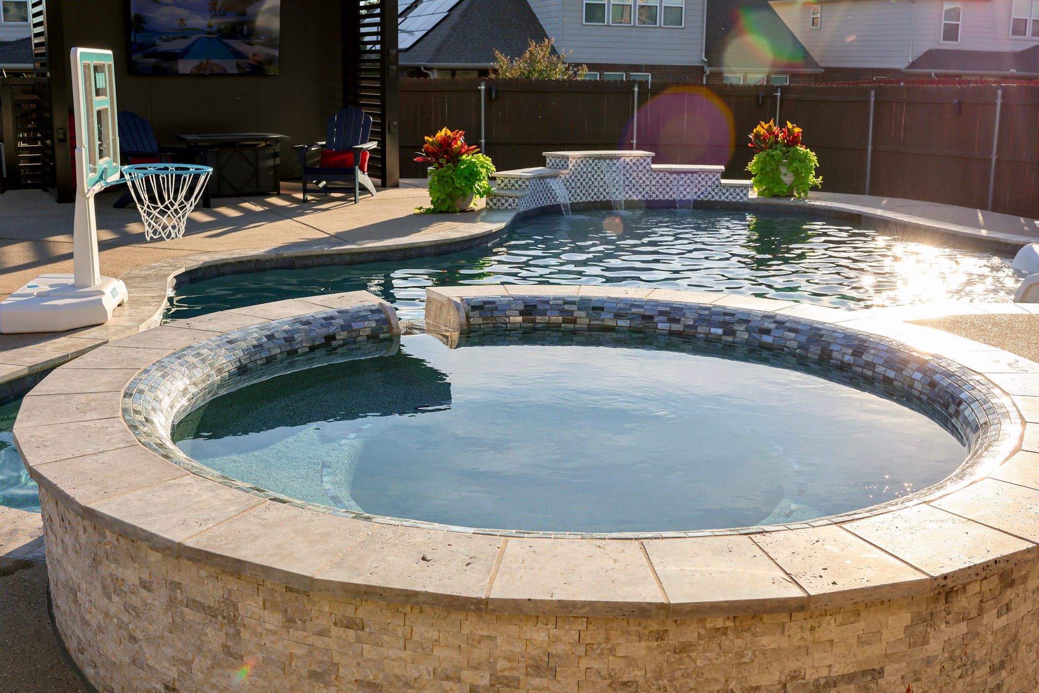 Circular raised spa overlooking a freeform swimming pool in Fort Worth