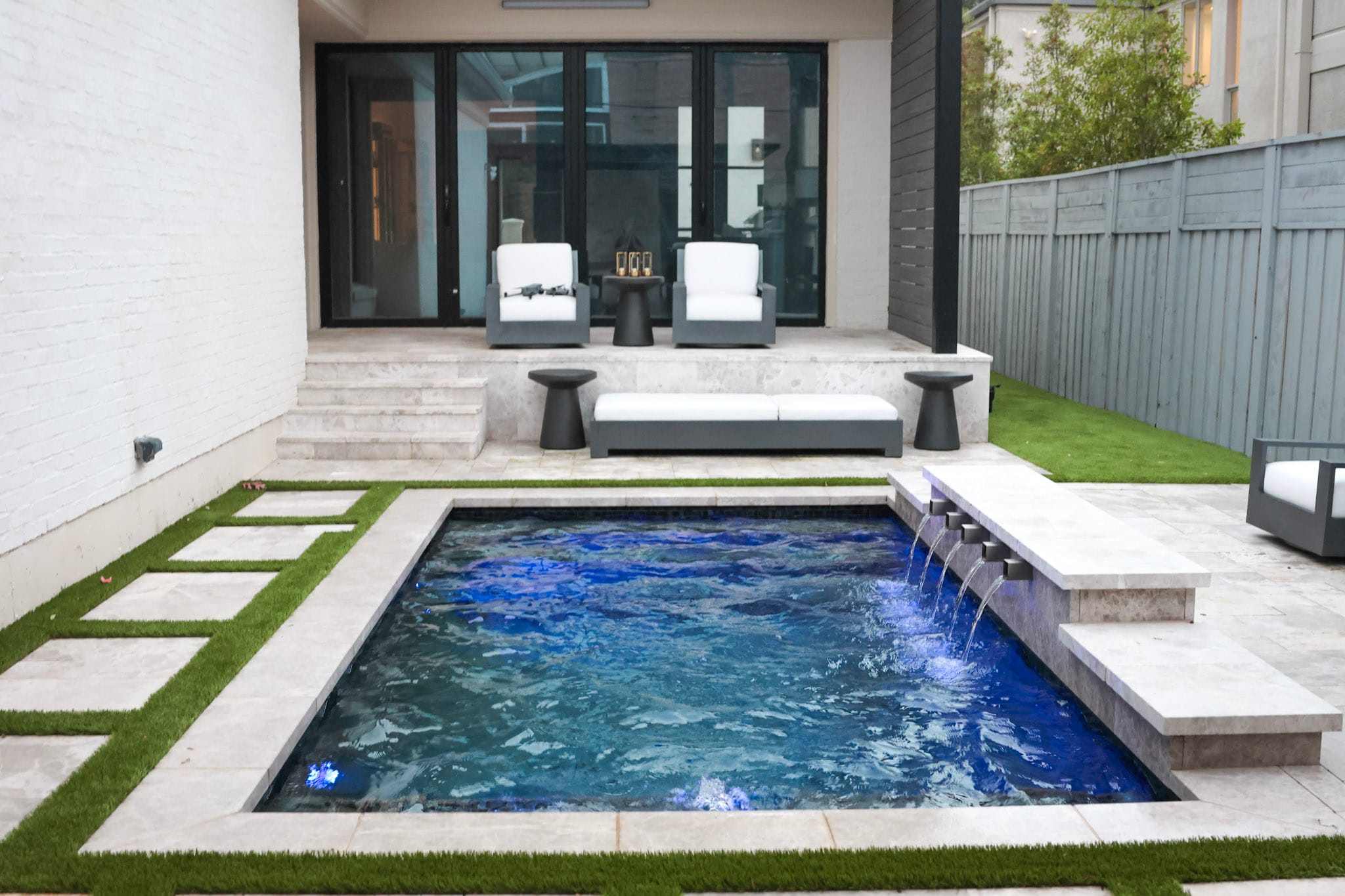 Rectangular pool with scuppers facing raised covered patio seating