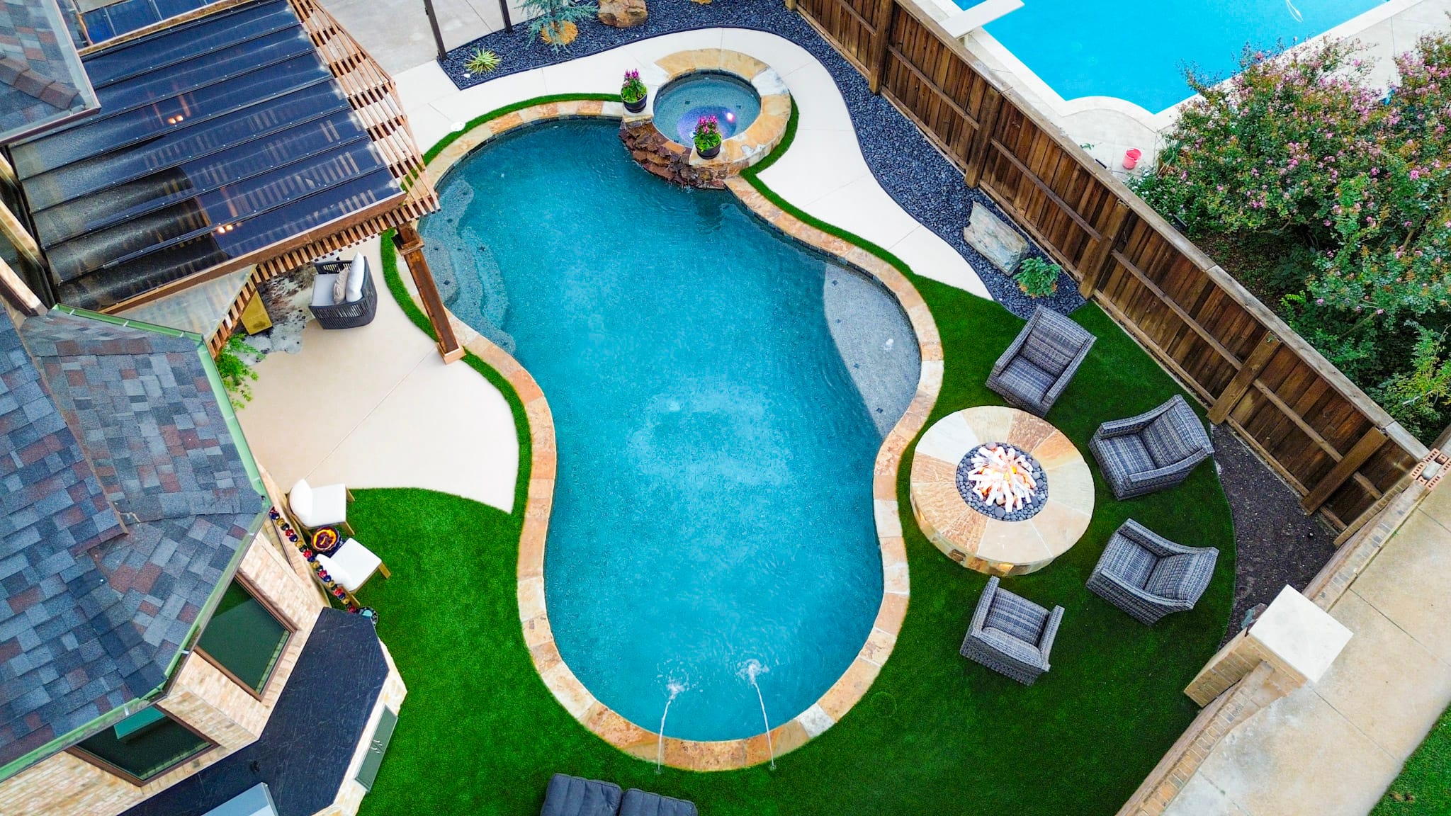 Aerial view of remodeled Coppell pool with spa, turf, fire pit, and covered patio