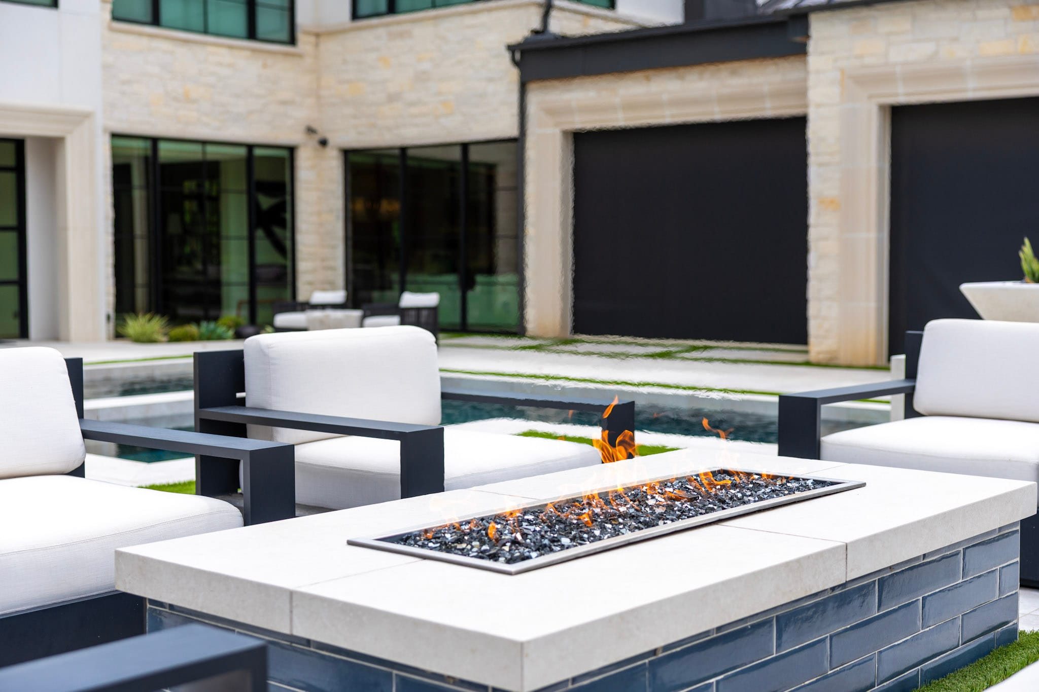 Rectangular fire feature with flames and surrounding outdoor chairs