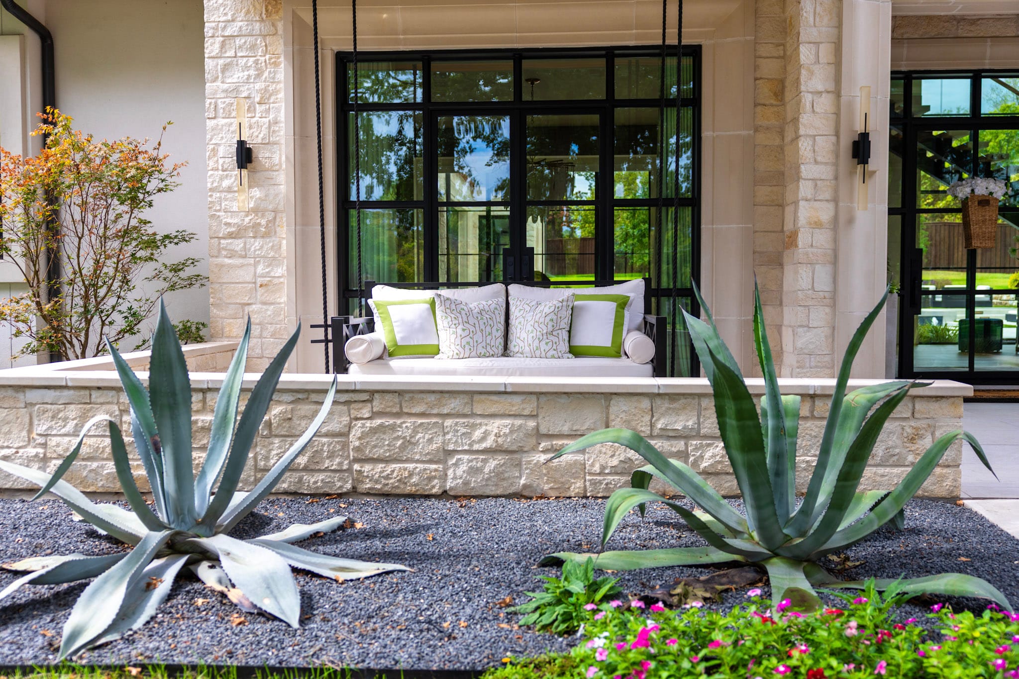 Front porch swing behind agave landscaping at Southlake home
