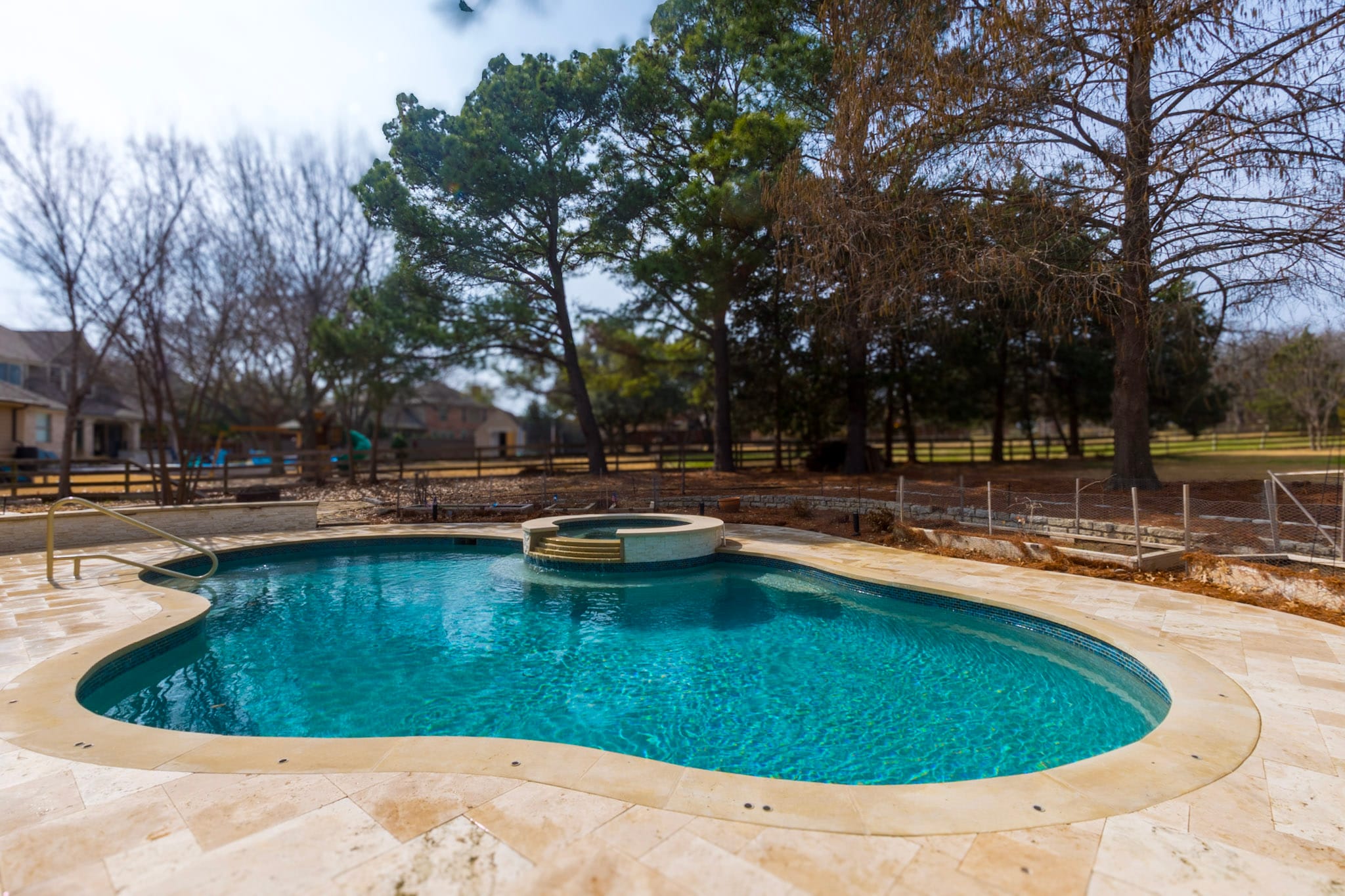 Freeform swimming pool with raised circular spa in Flower Mound