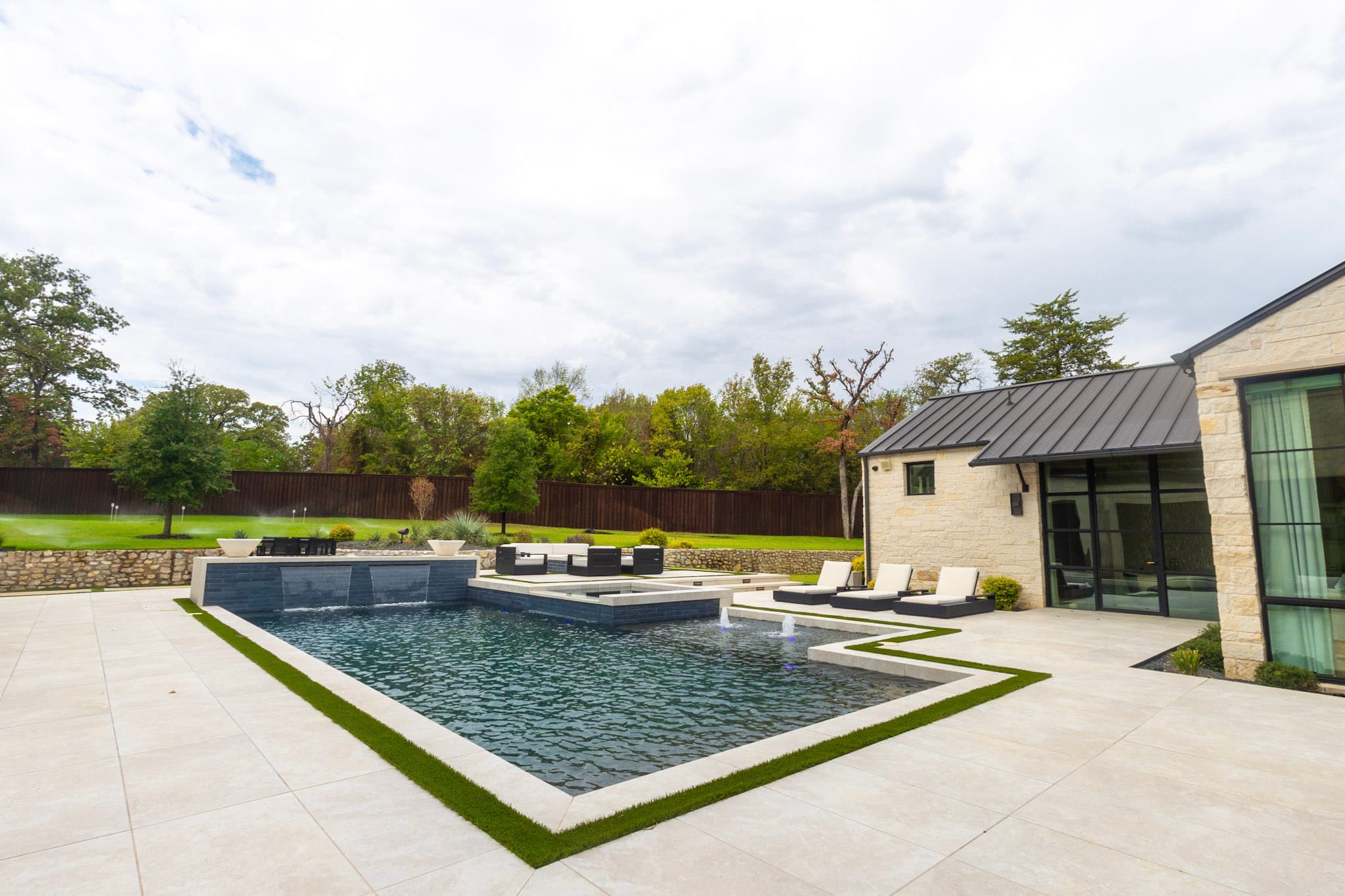 Wide luxury pool with spa, lounge areas and stone architecture in Southlake