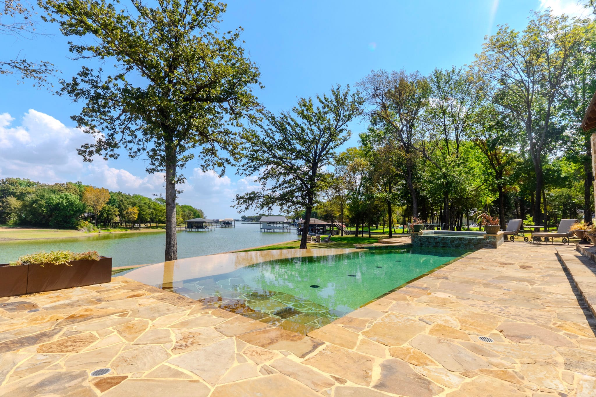 Wide pool and flagstone patio with trees and Richland Chambers Reservoir beyond