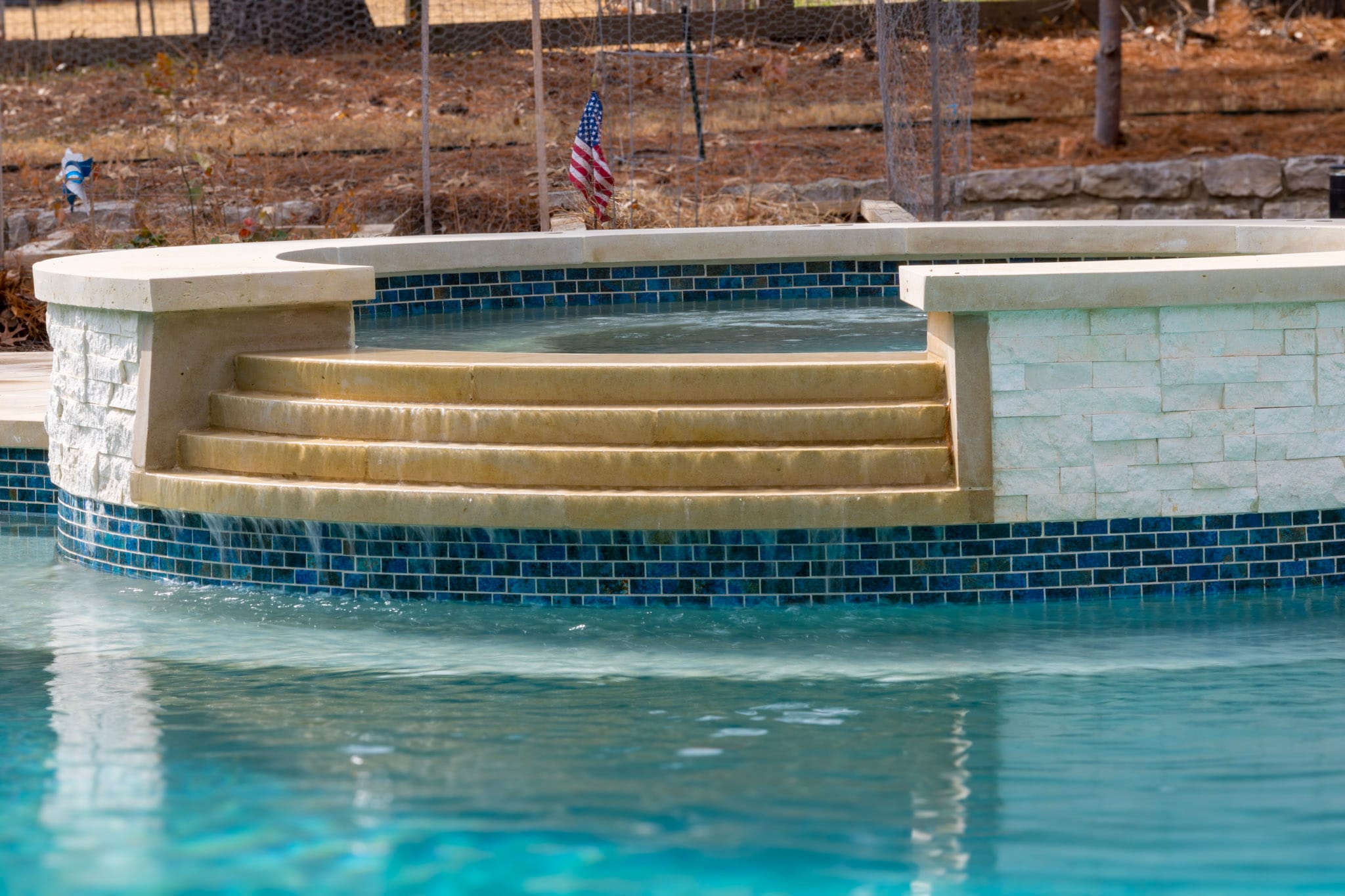 Curved stepped spillway connecting a raised spa with the pool