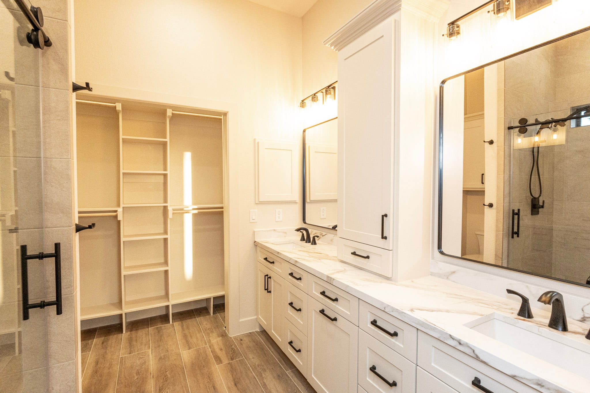 Double vanity bathroom with walk-in closet and glass shower