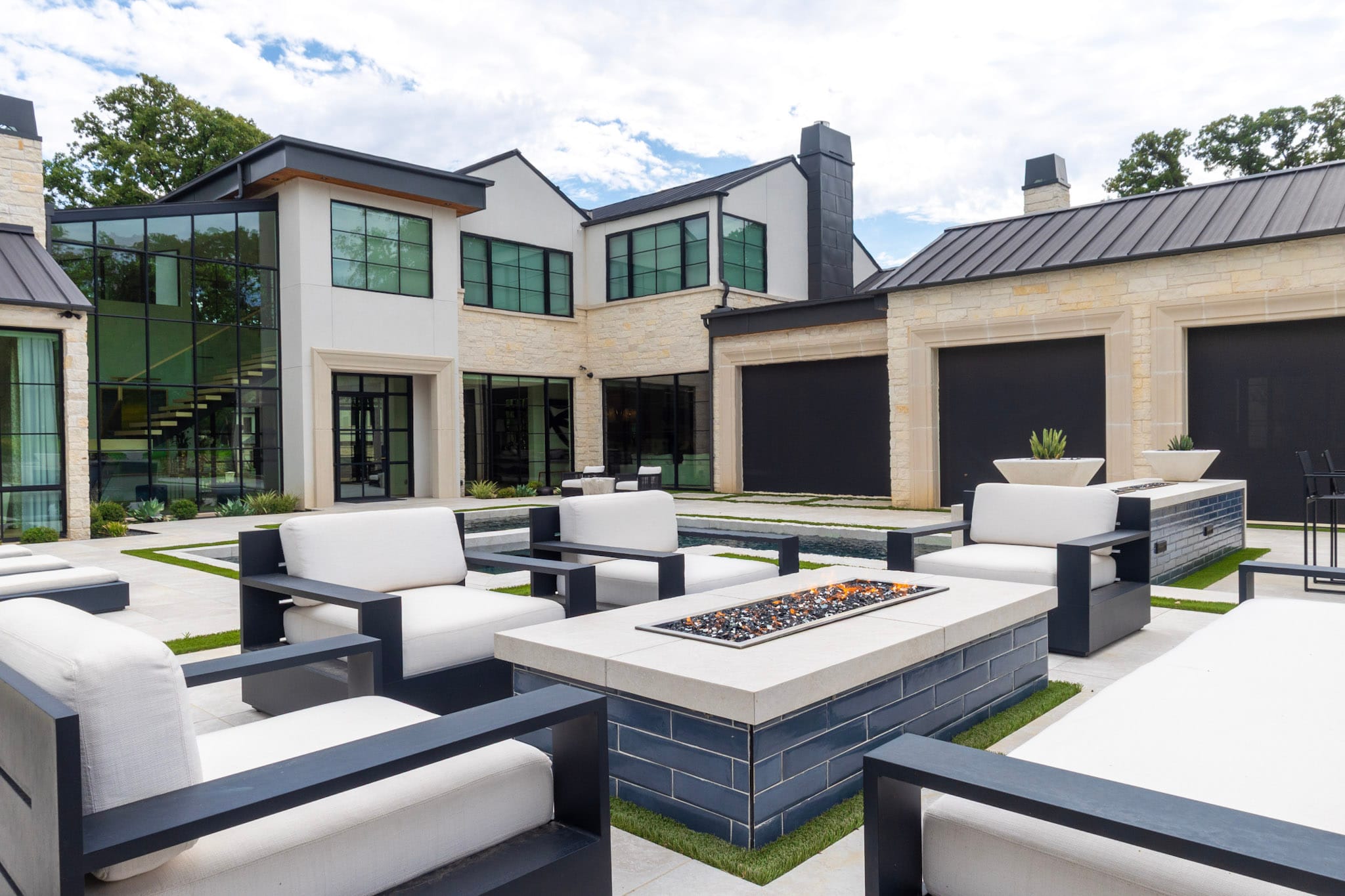 Modern fire pit surrounded by outdoor lounge chairs in Southlake backyard