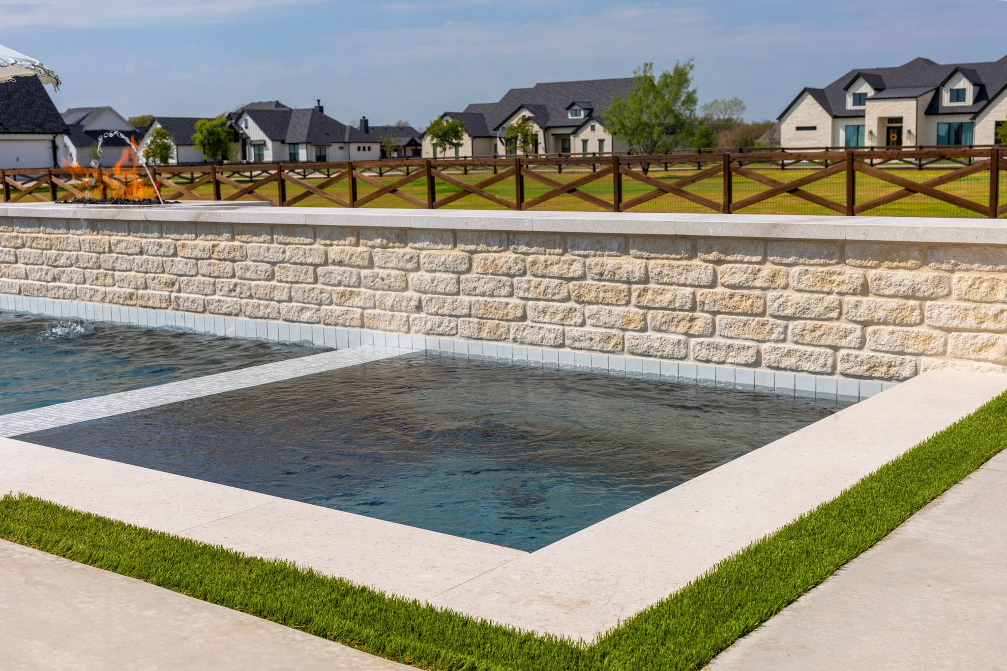 Integrated spa beside stone pool wall in Northlake backyard