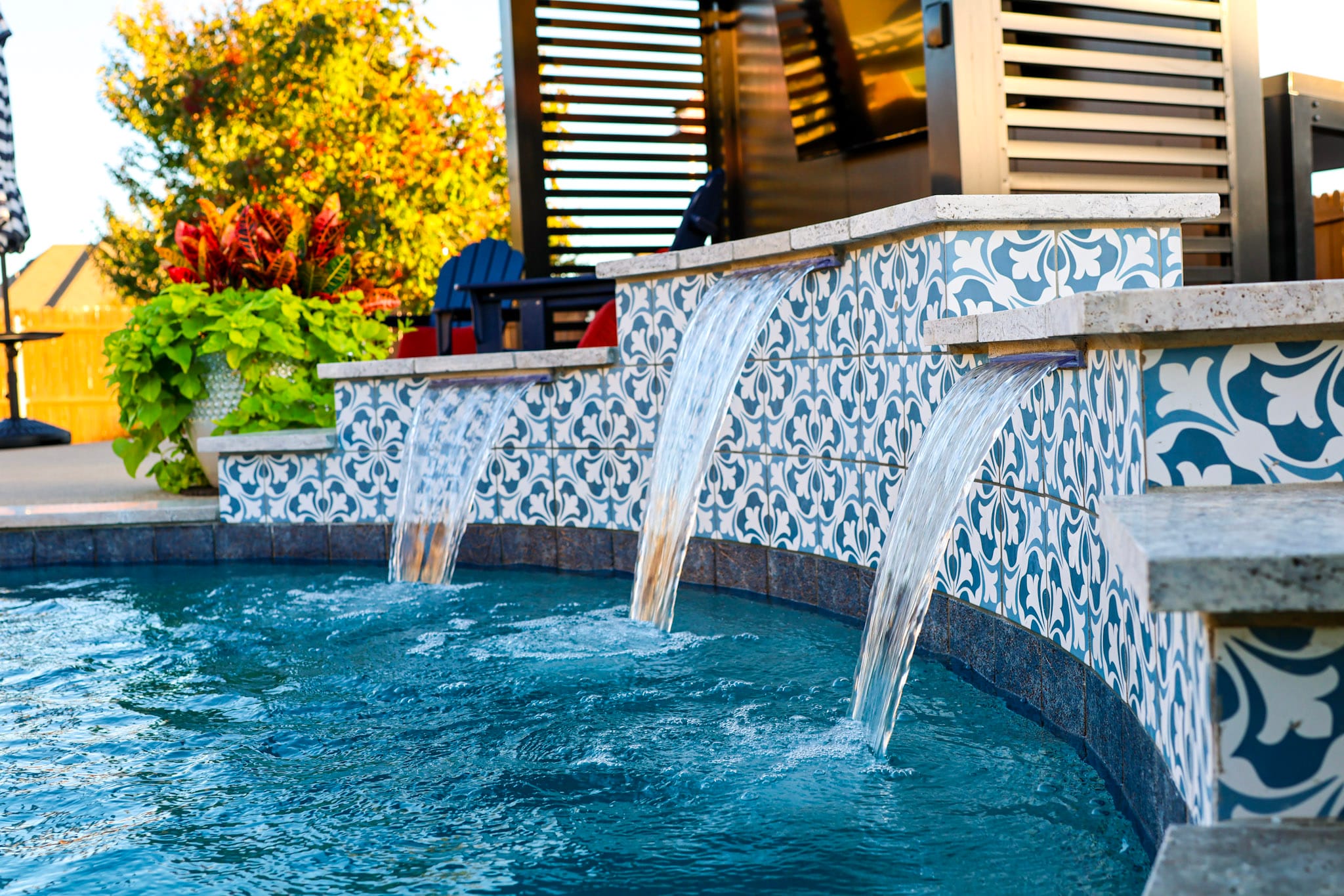 Close view of three spillways flowing into a residential swimming pool
