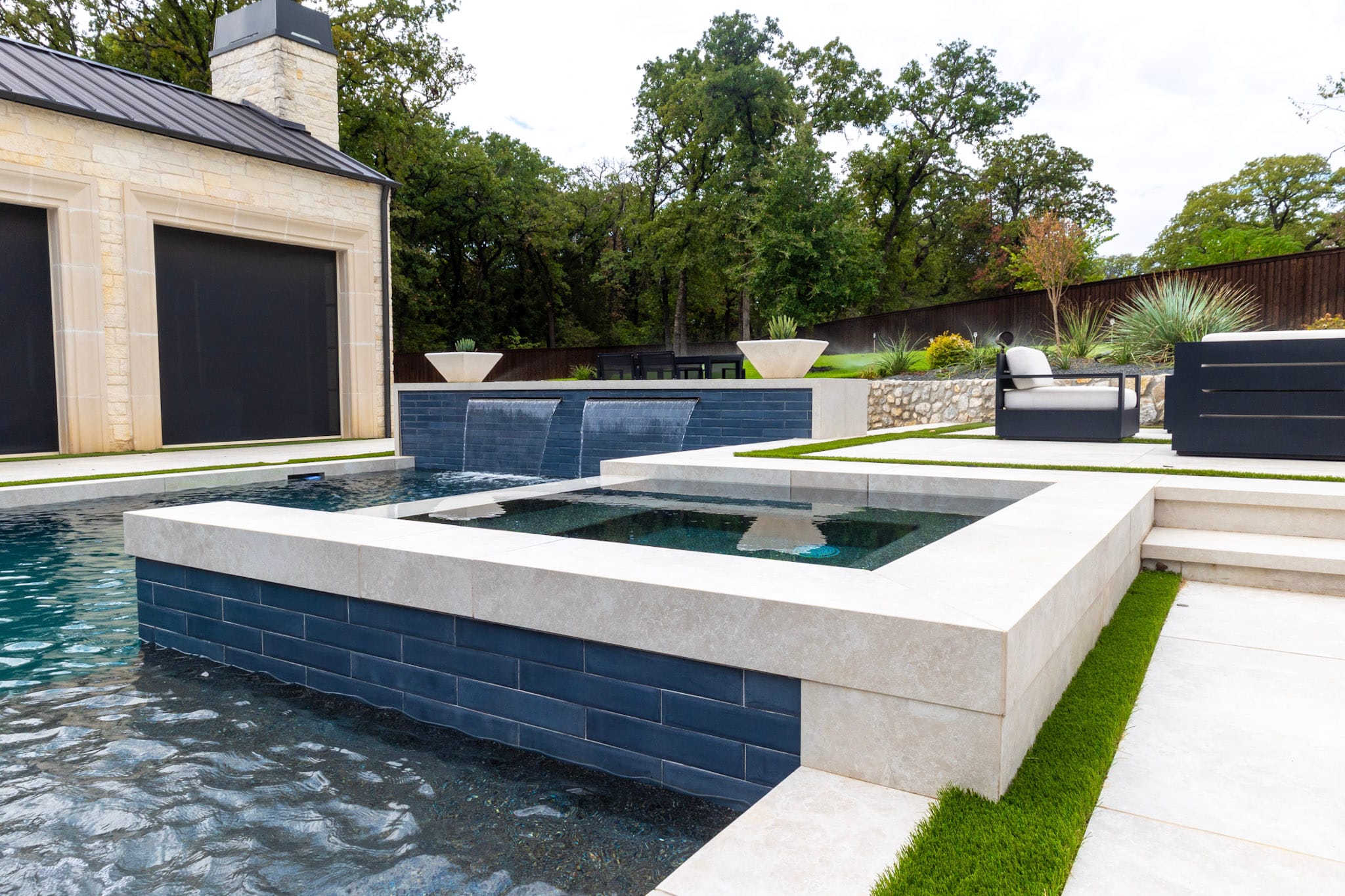 Wide Southlake backyard with pool, spa, porcelain deck and stone home