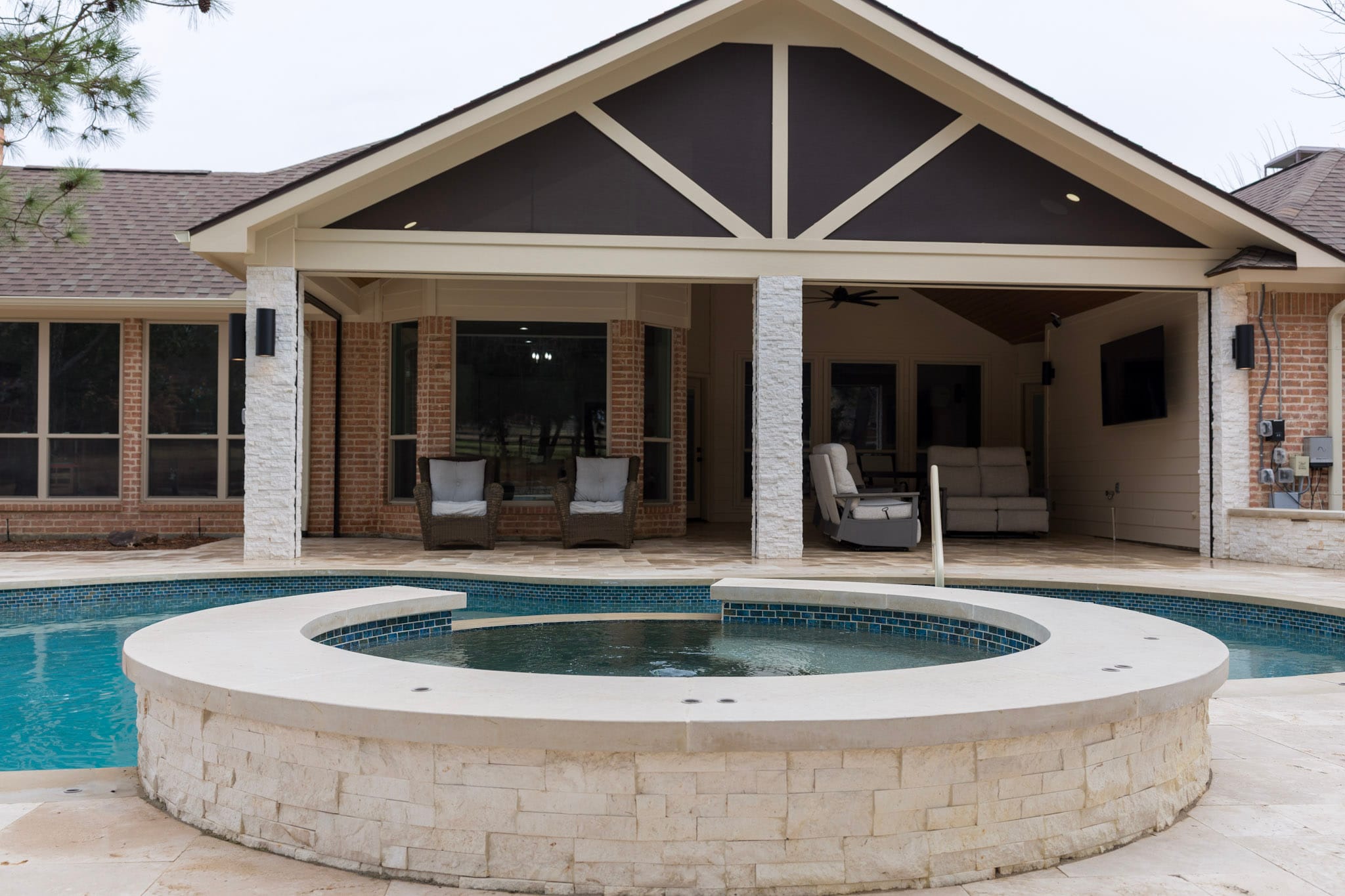 Circular raised spa in front of a covered outdoor living area