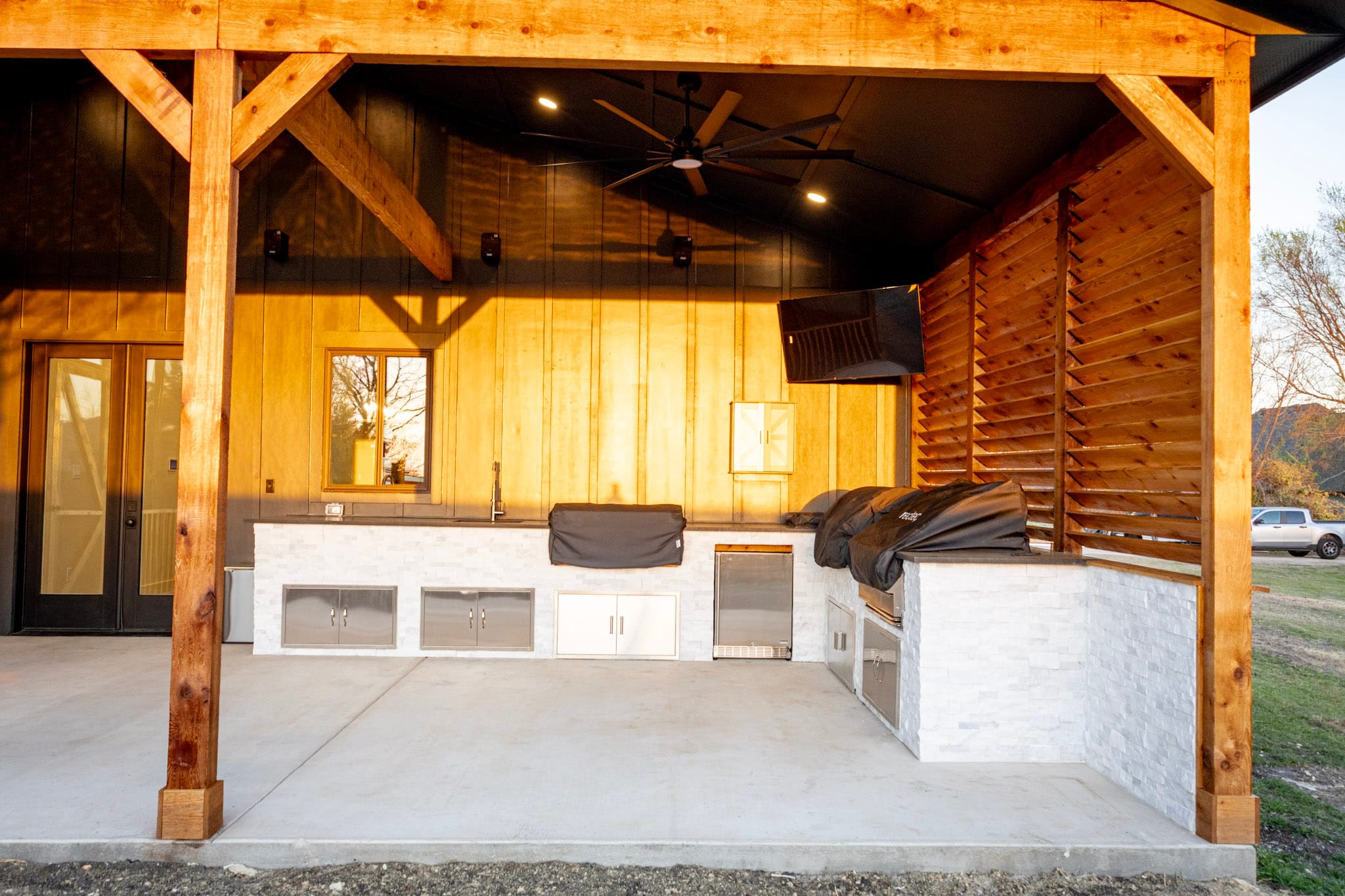 Outdoor kitchen beneath timber-framed covered patio in Celina Texas