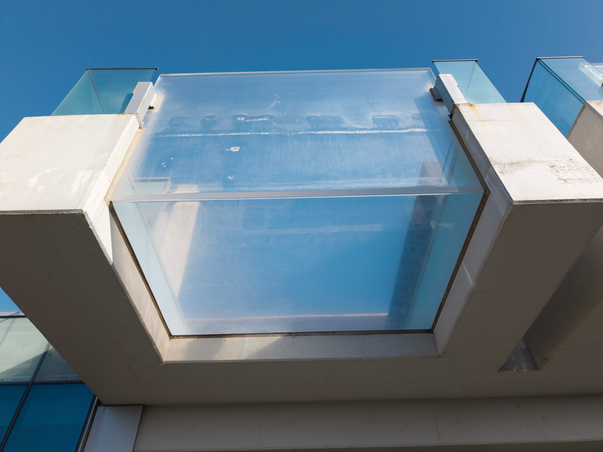Large transparent pool panel between structural supports at Bleu Ciel