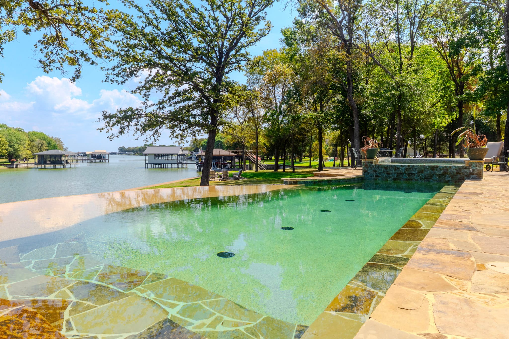 Lakefront pool with broad shallow shelf, raised spa, and reservoir views