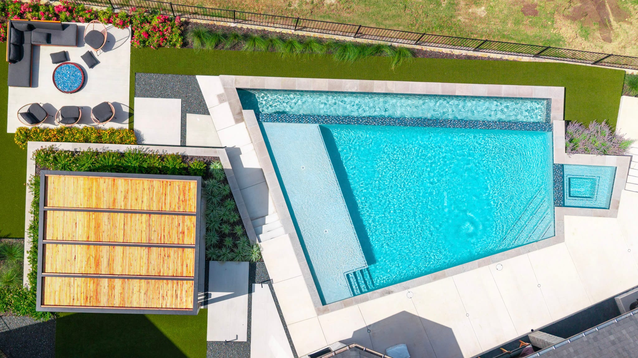 Top-down aerial view of vanishing edge pool, spa, pavilion, and fire pit area