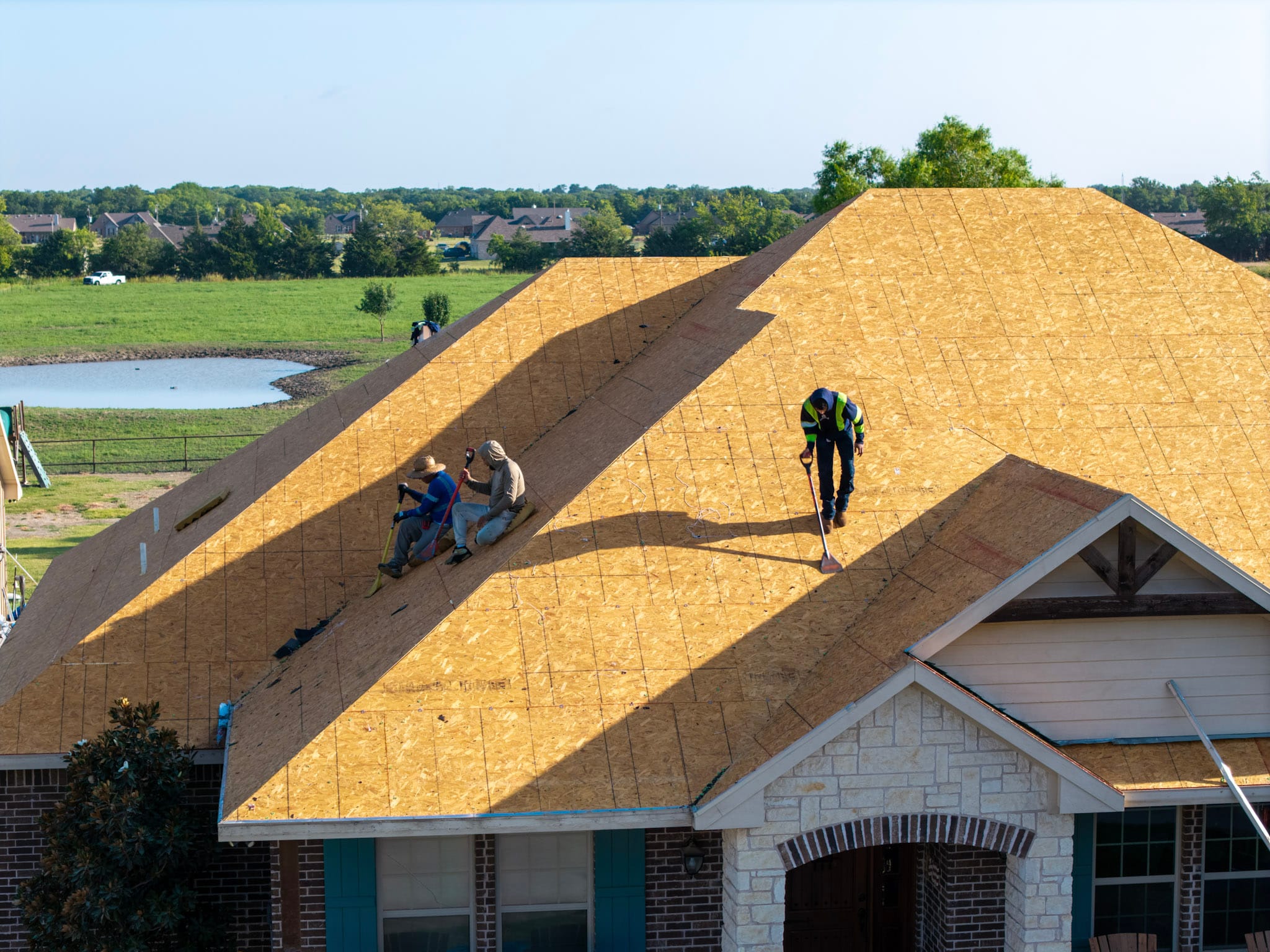 Wide aerial view of active roofing project and surrounding property in Leonard Texas