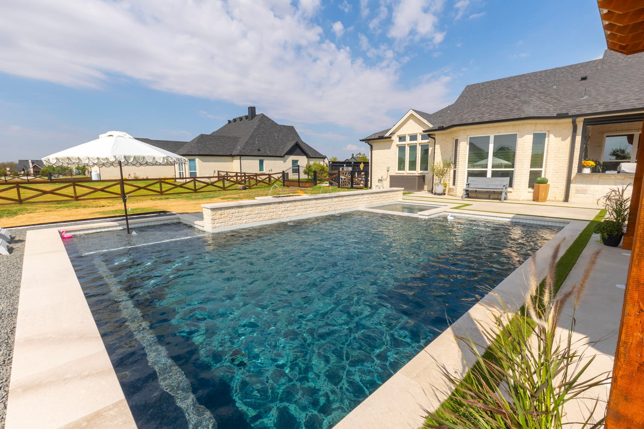Northlake backyard swimming pool beside white brick home