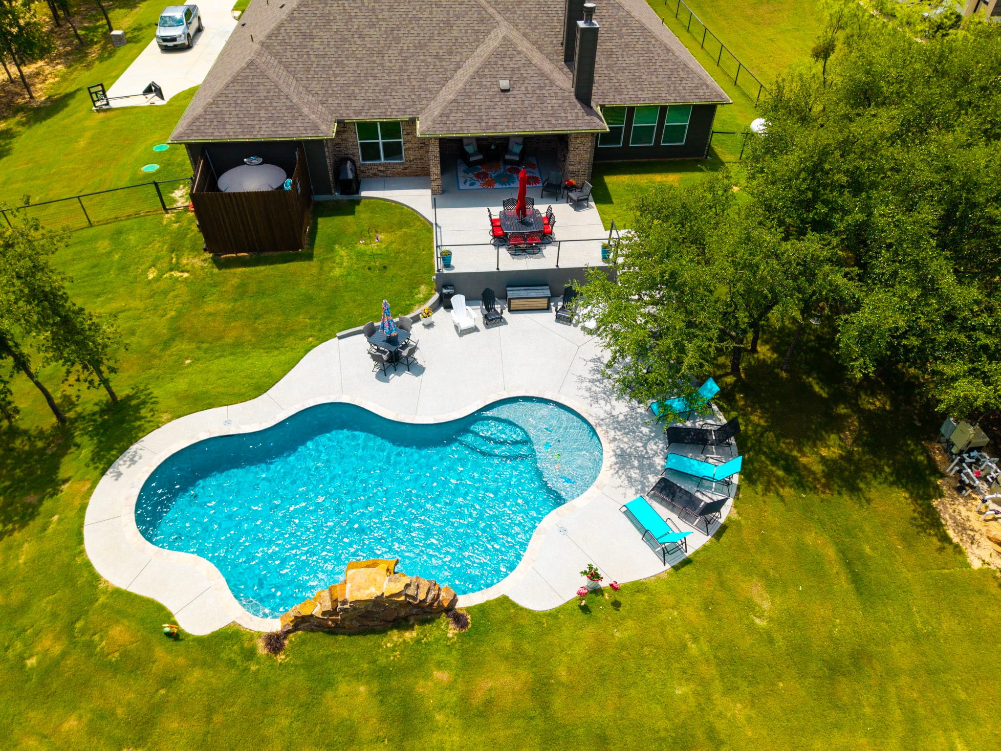 Aerial view of Weatherford home with freeform swimming pool and backyard