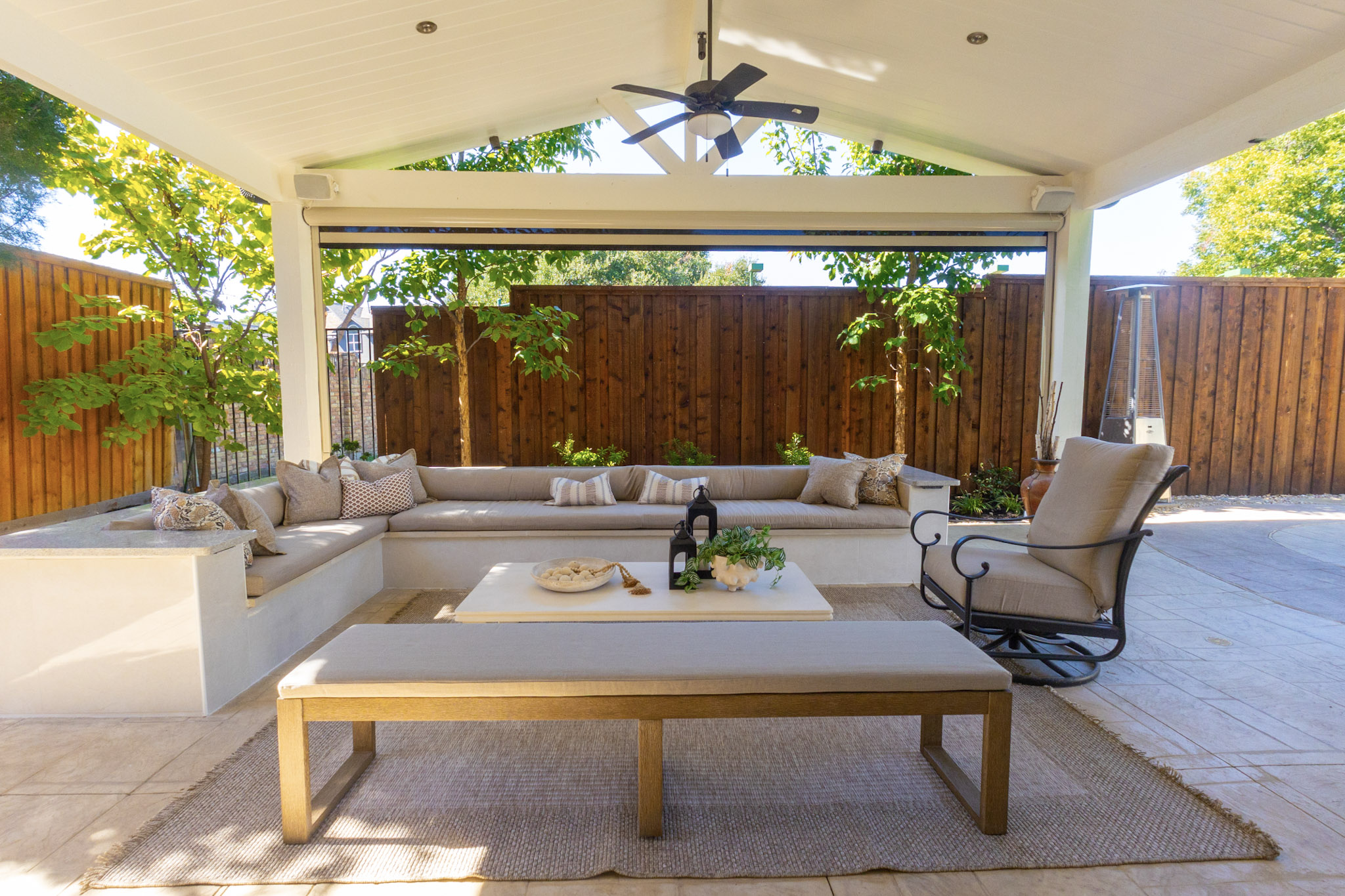 Outdoor kitchen counter with decorative glass vessels and potted plant