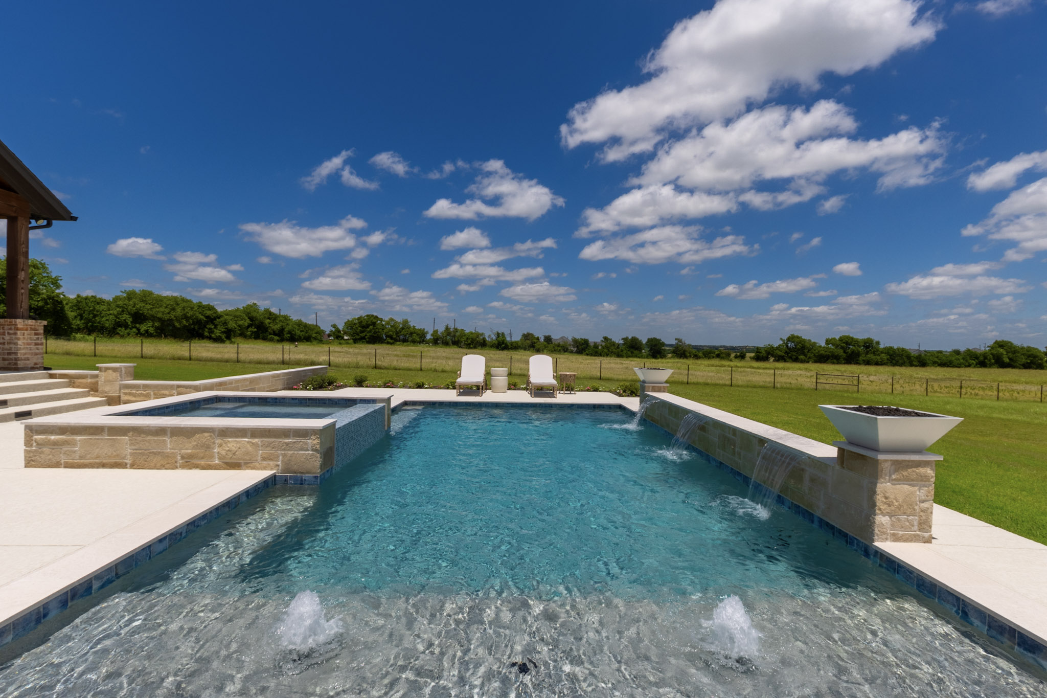 Shallow pool ledge with two bubblers facing three sheer descents and fire bowls