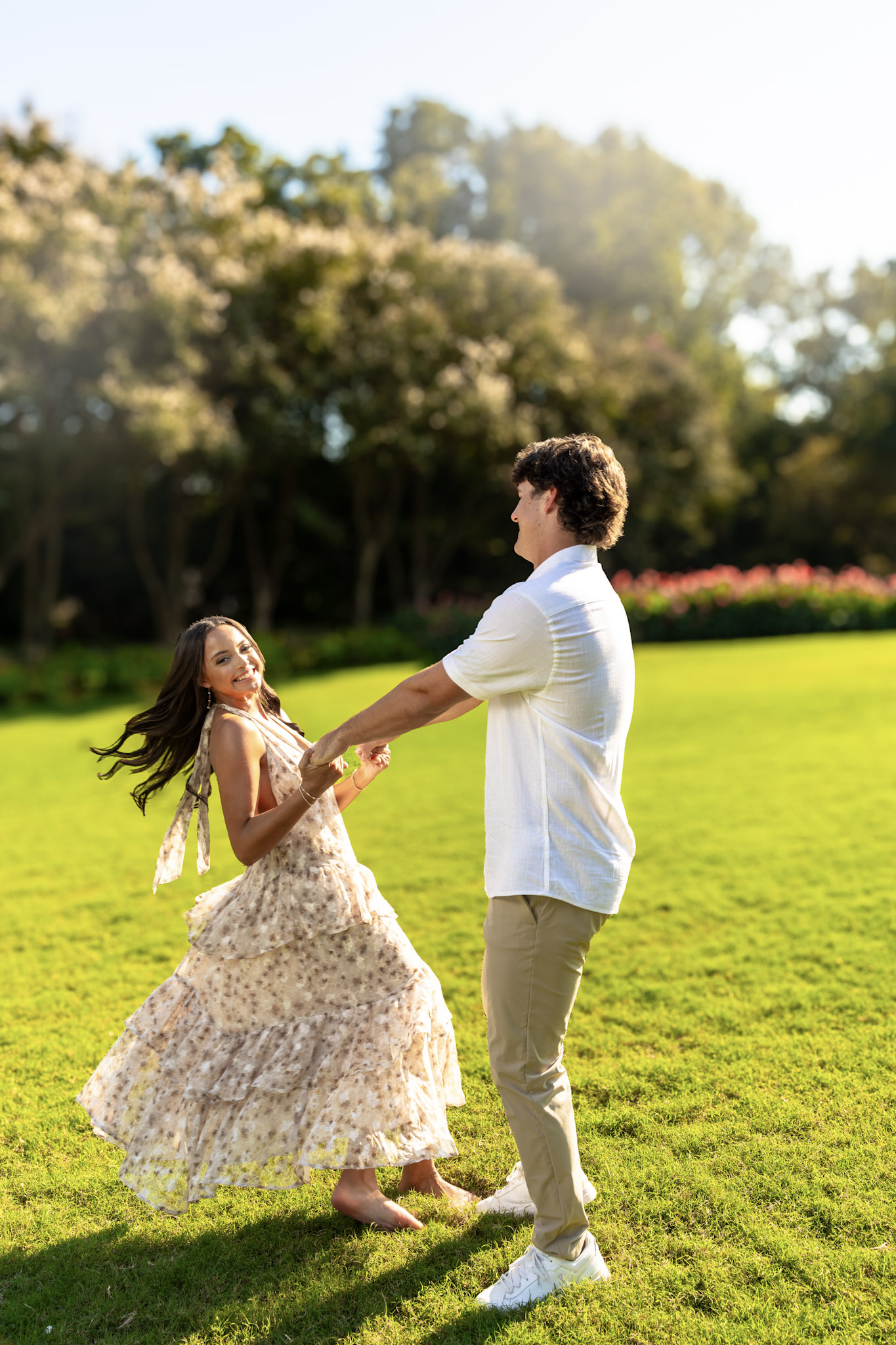 Couple holding hands and spinning together on a green lawn